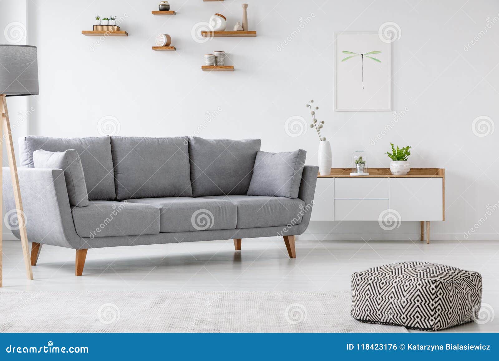 patterned pouf and grey couch in minimal living room interior wi