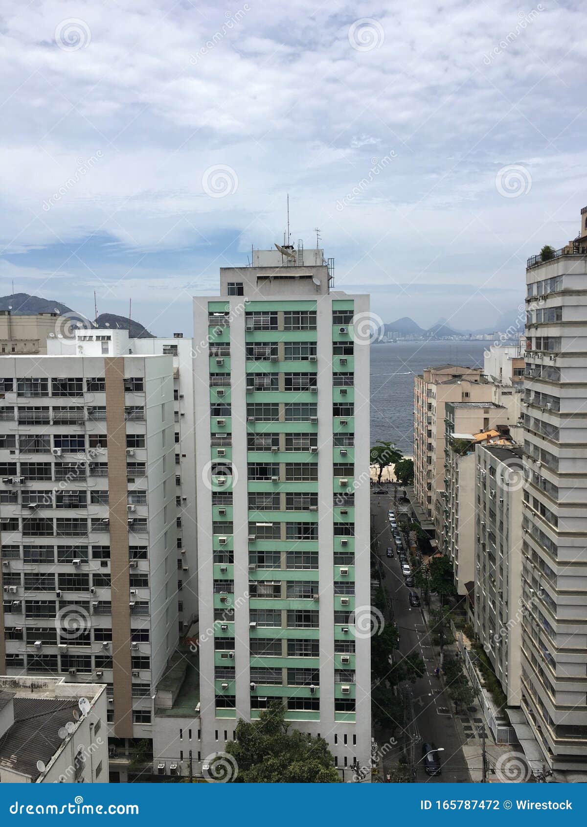 Un paesaggio di grattacieli sotto un cielo nuvoloso con la spiaggia a Rio De Janeiro sullo sfondo