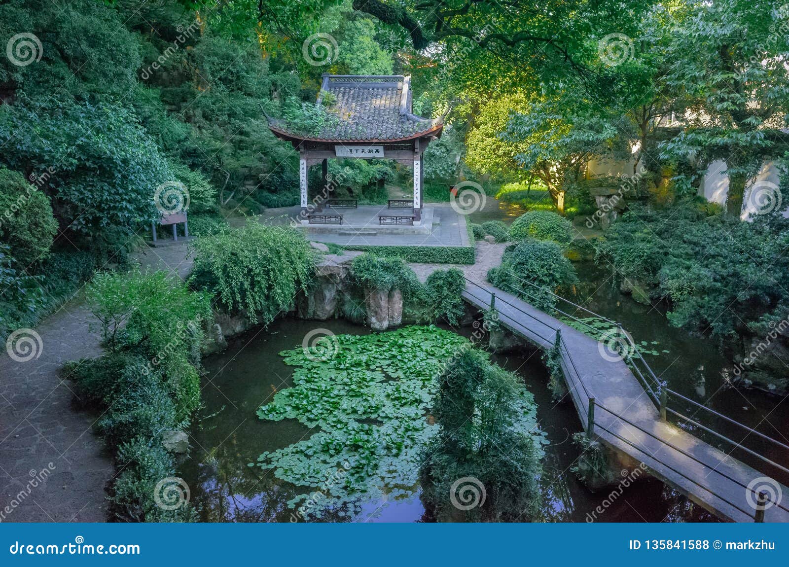 Ansicht des Pavillons und der Brücke über Teich in Zhongshan-Park auf GU-Hügel, nahe Westsee von Hangzhou, China