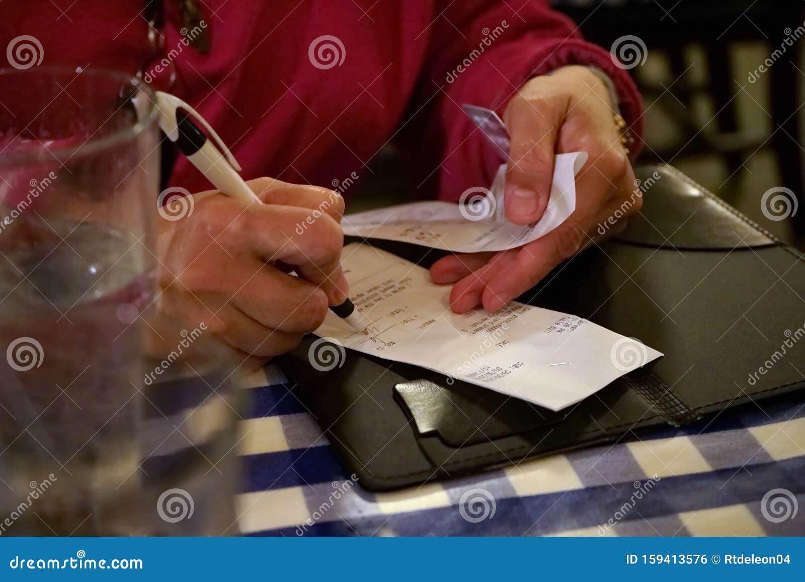 hands calculating tip on restaurant receipt