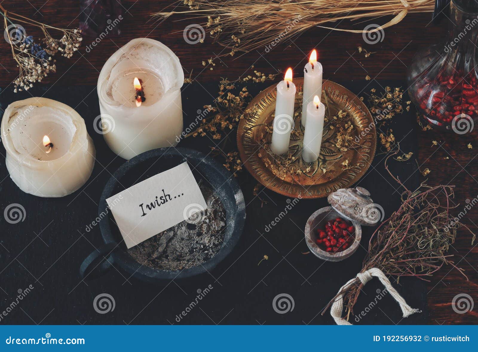 peace of paper with words i wish written on it, put in cast iron candle holder with ashes in it, on wiccan witch altar.