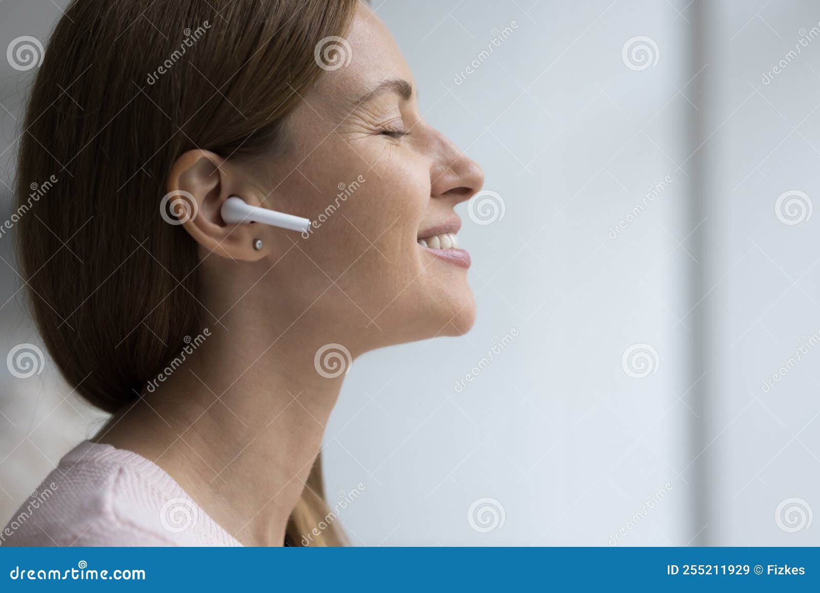 peaceful happy woman with closed eyes listening to relaxing musing