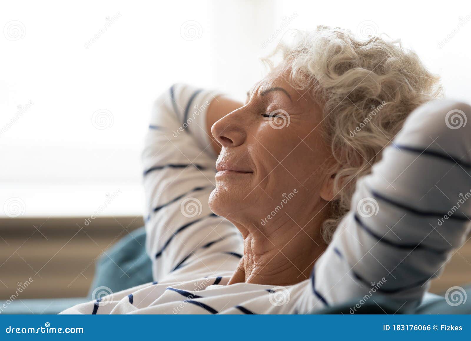 peaceful mindful mature senior grandmother daydreaming at home.