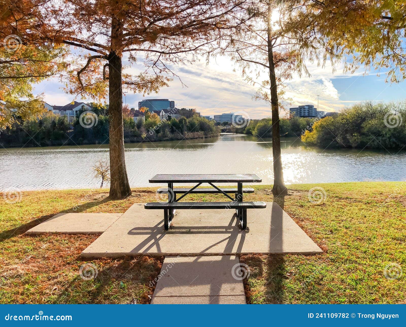 peaceful riverside picnic table and corporate building offices along trinity river near dallas, texas, america