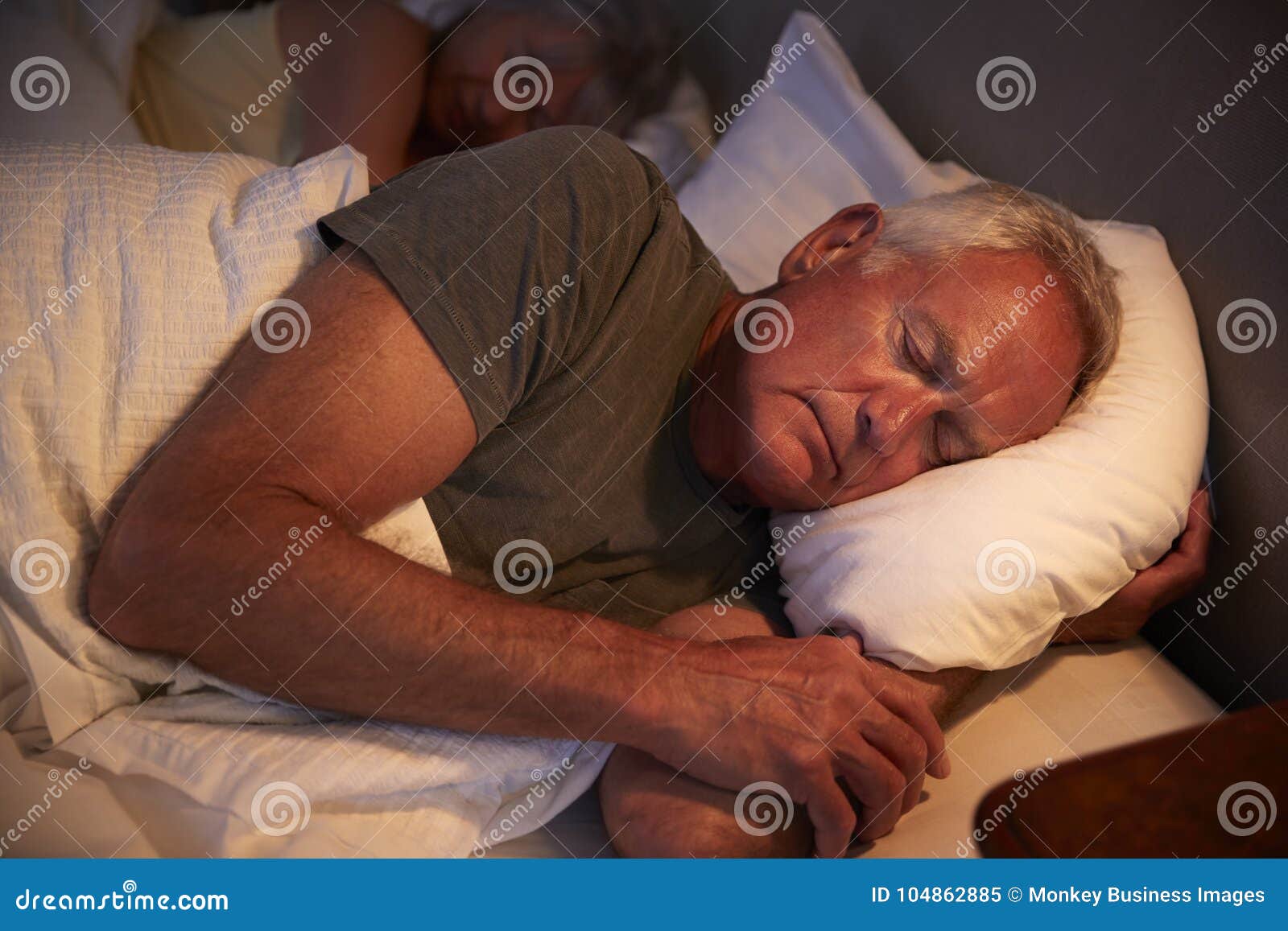 peaceful senior man asleep in bed at night