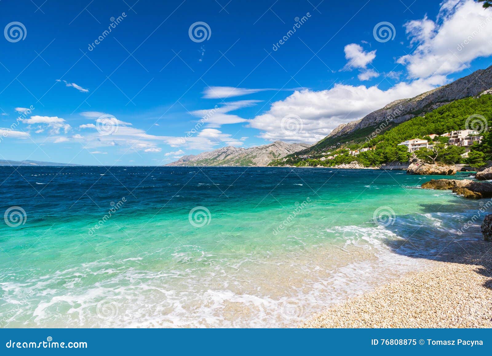 peaceful and transparent summer sea, mountainous landscape in the background
