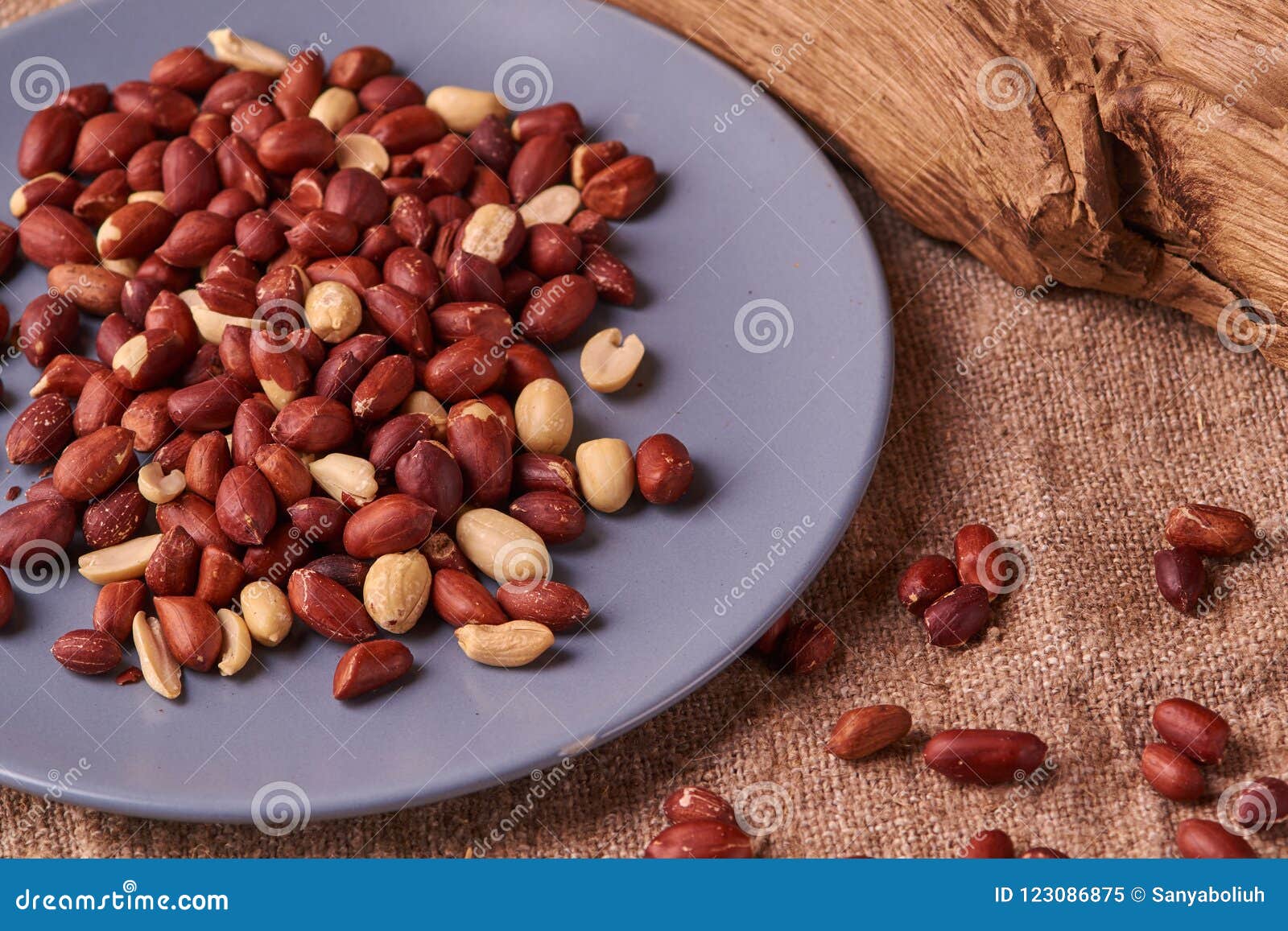peanut snacks nuts eating snacks red peanuts peanuts fried peanuts on blue plate on sackcloth. selective focus