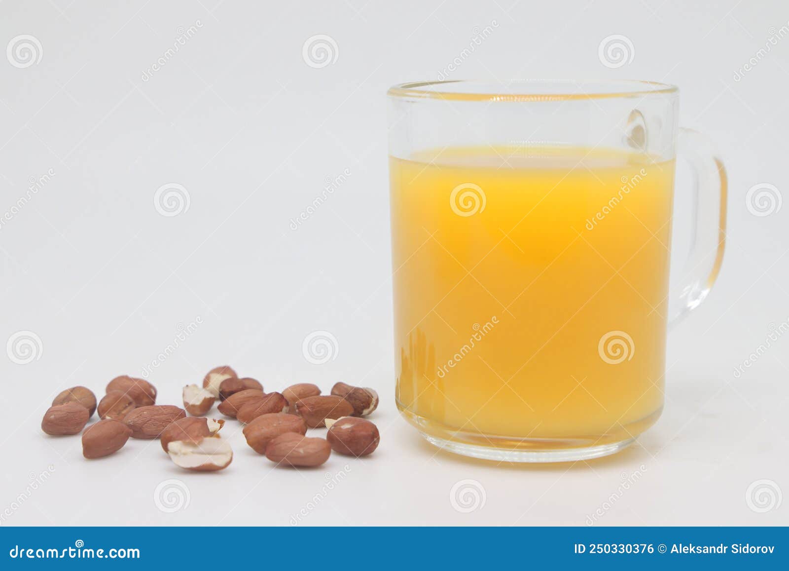 Peanuts in a Bowl and a Glass of Orange Juice. Separate on a White