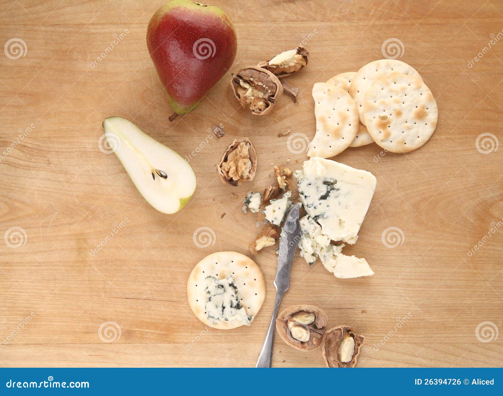 Pears, walnuts and blue cheese. Chunk of blue cheese with crackers, pear and walnuts on a cutting board