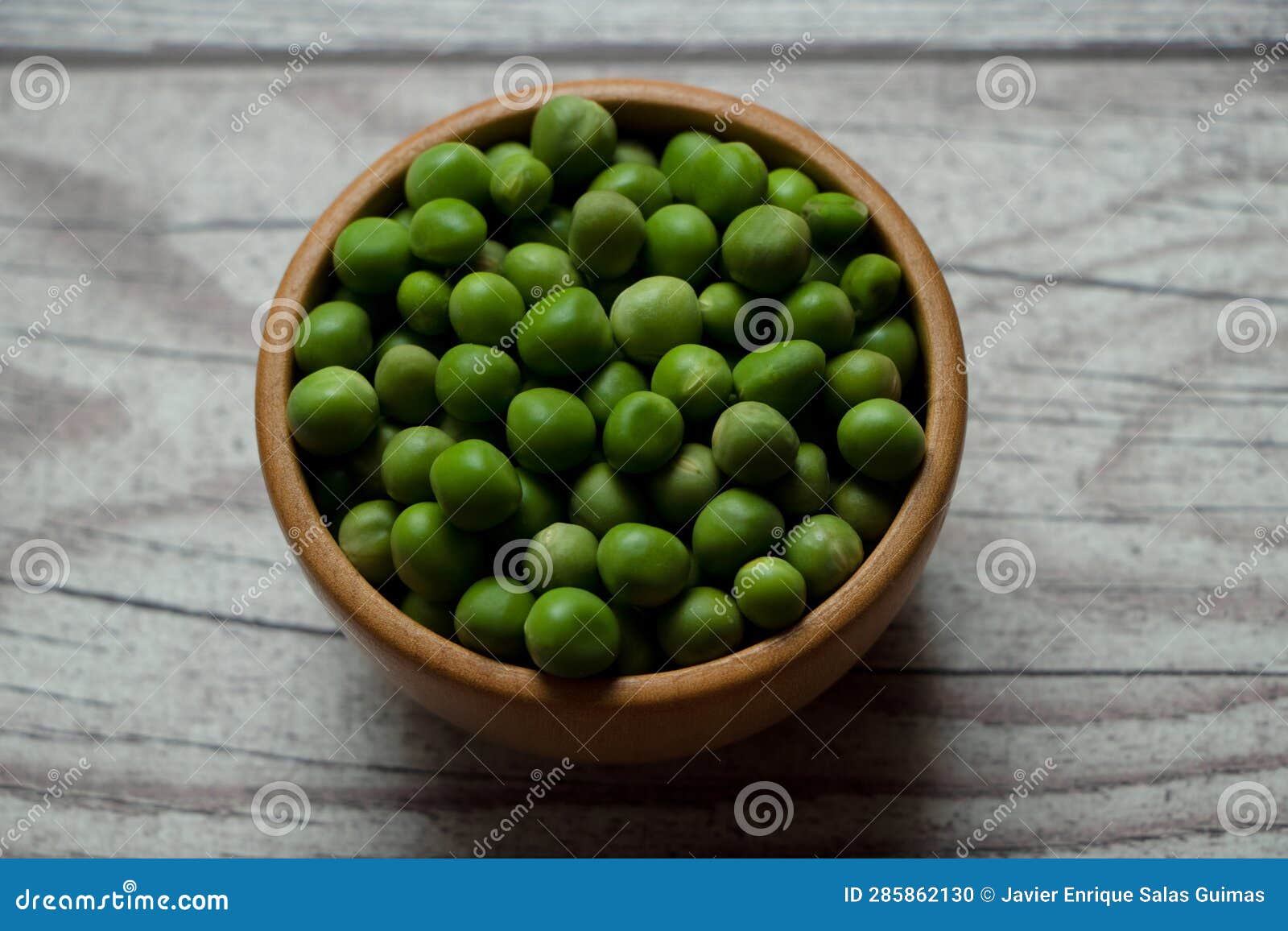 peas in a wooden bowl on a rustic table