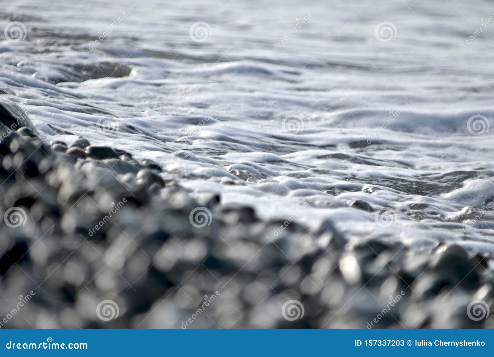 pebble beach covered by sea foam.