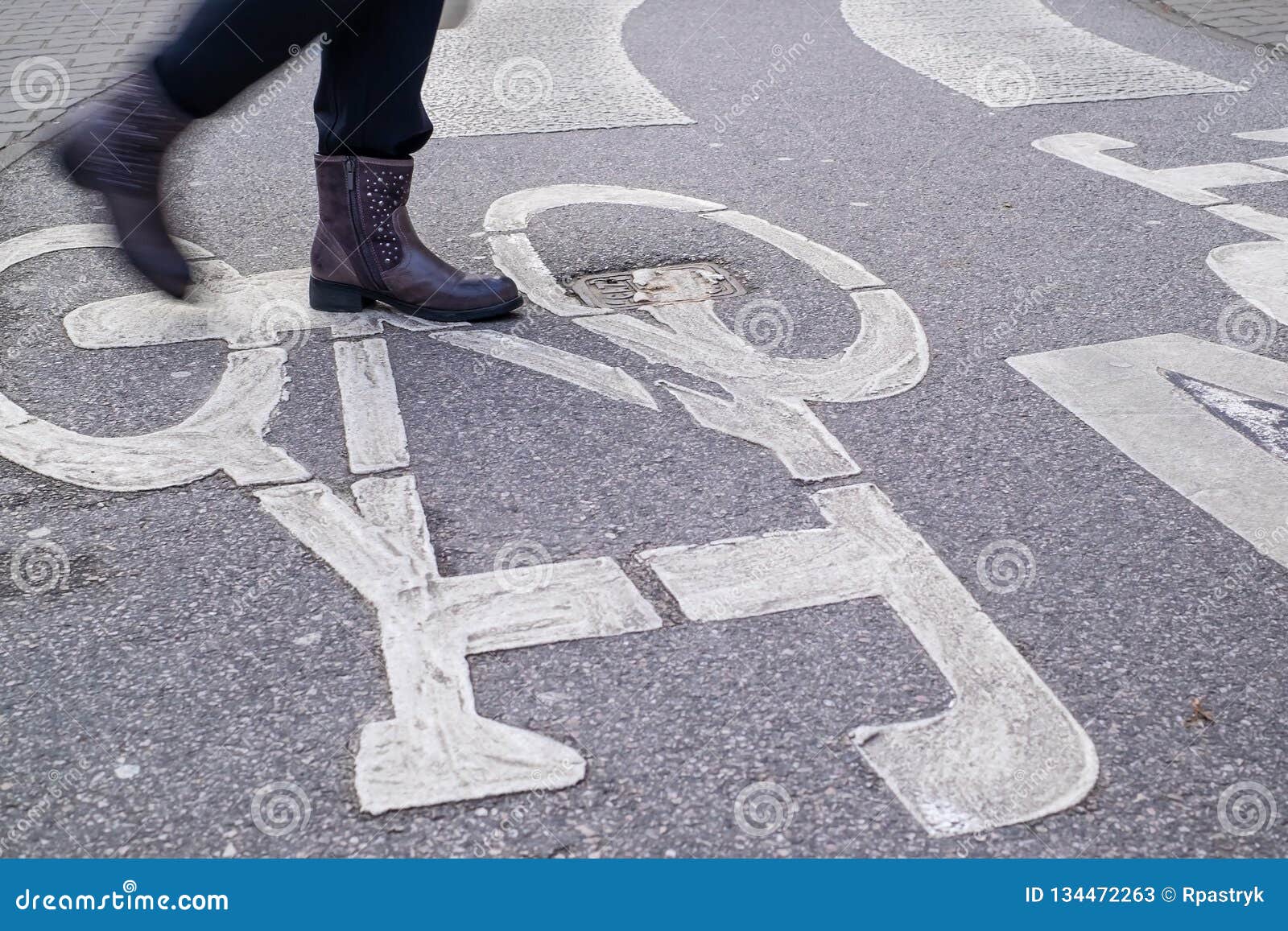 pedestrian crossing across curved bicycle asphalt line, one person