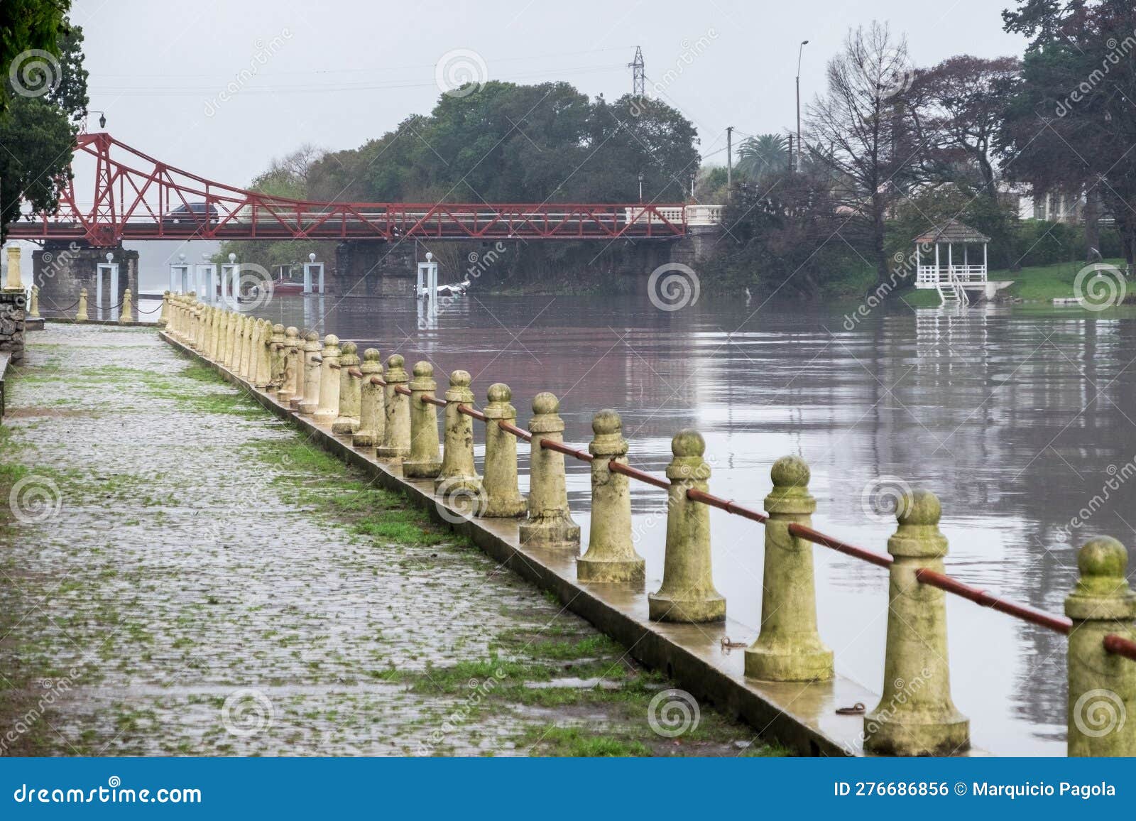 pedestrian walk along the river, with the carmelo bridge during a rainy day