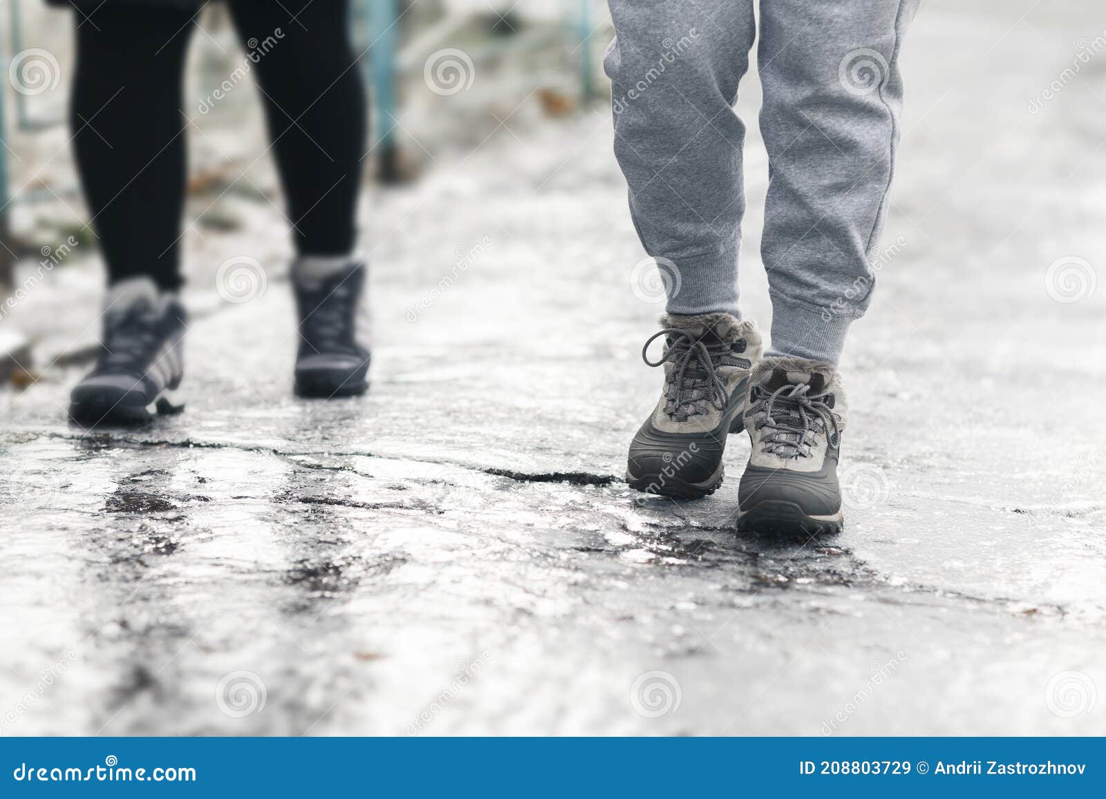 pedestrians glide along the icy sidewalk. winter ice on footpaths