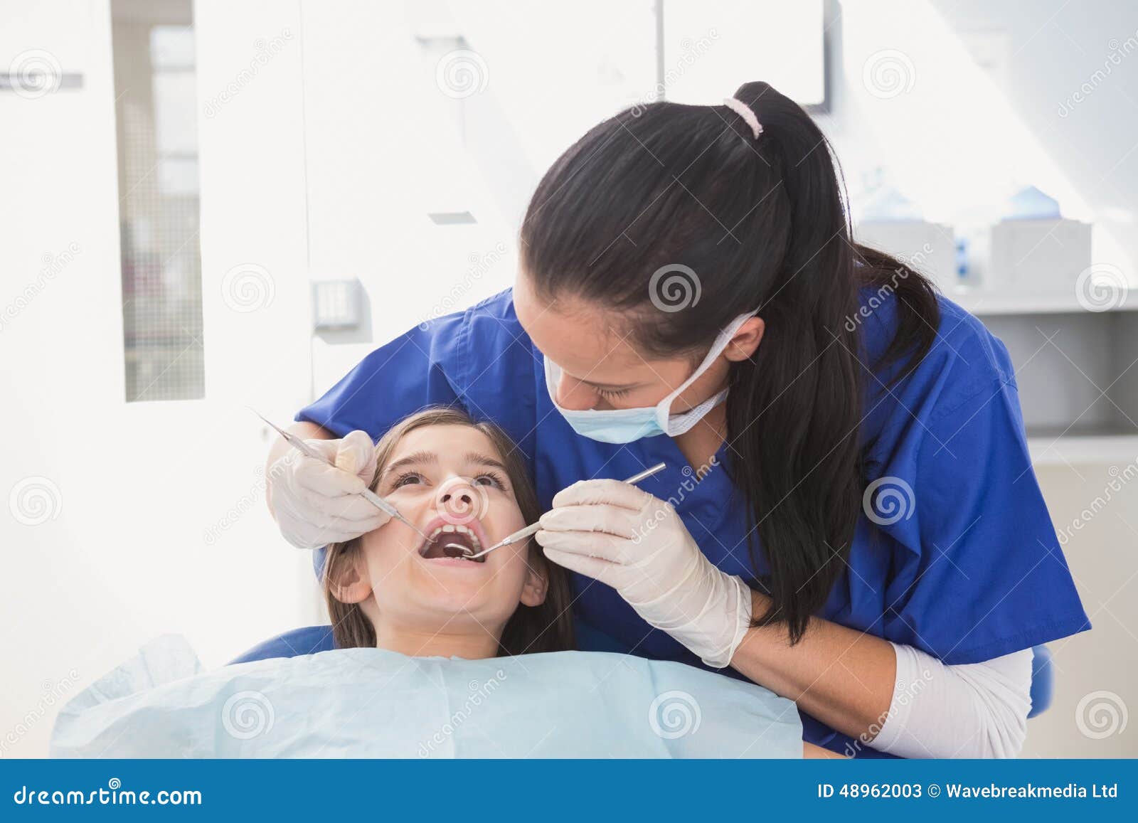 Pediatric Dentist Using Dental Explorer and Angled Mirror Stock Image