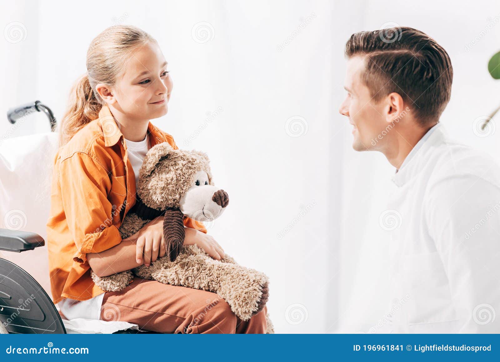 pediatrist and kid with teddy bear on wheelchair