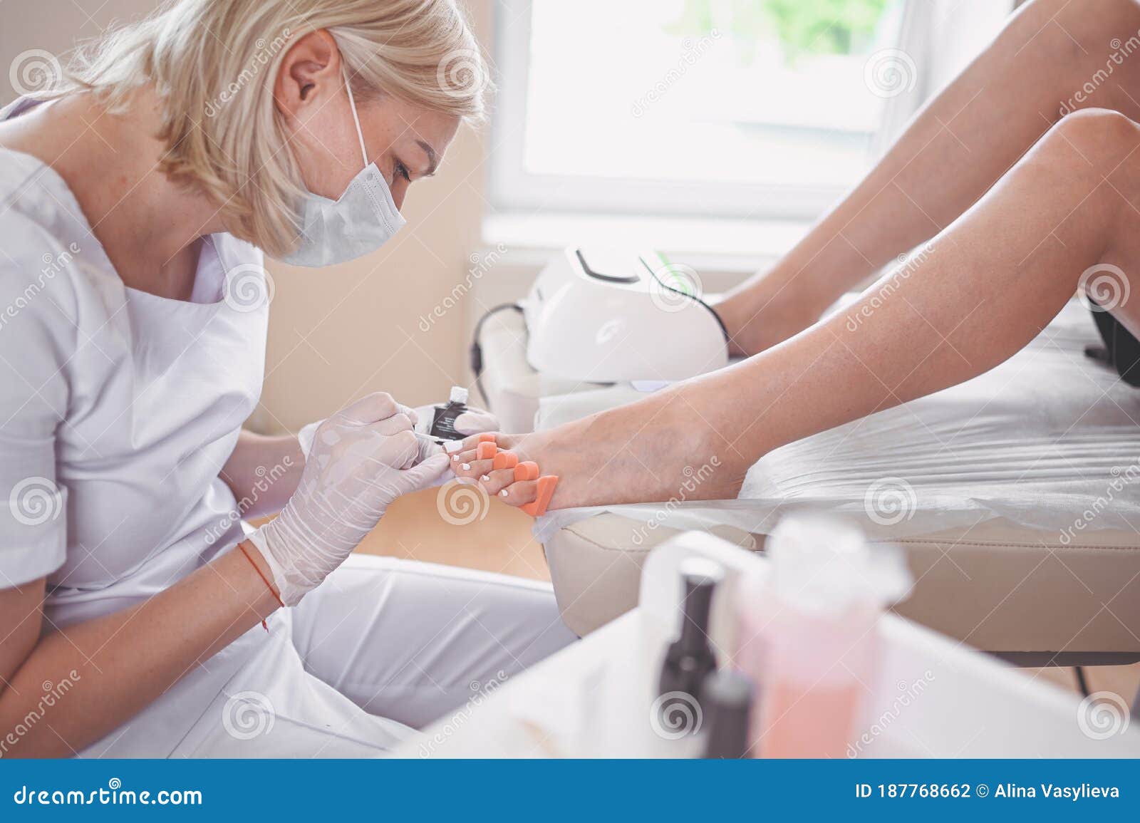 Pedicure Che Praticano Lo Smalto Per Unghie Bianche Sulle Gambe Dei Clienti Con  Lampada a Gomito. Procedura Medica Professionale. Fotografia Stock -  Immagine di umano, piedi: 187768662