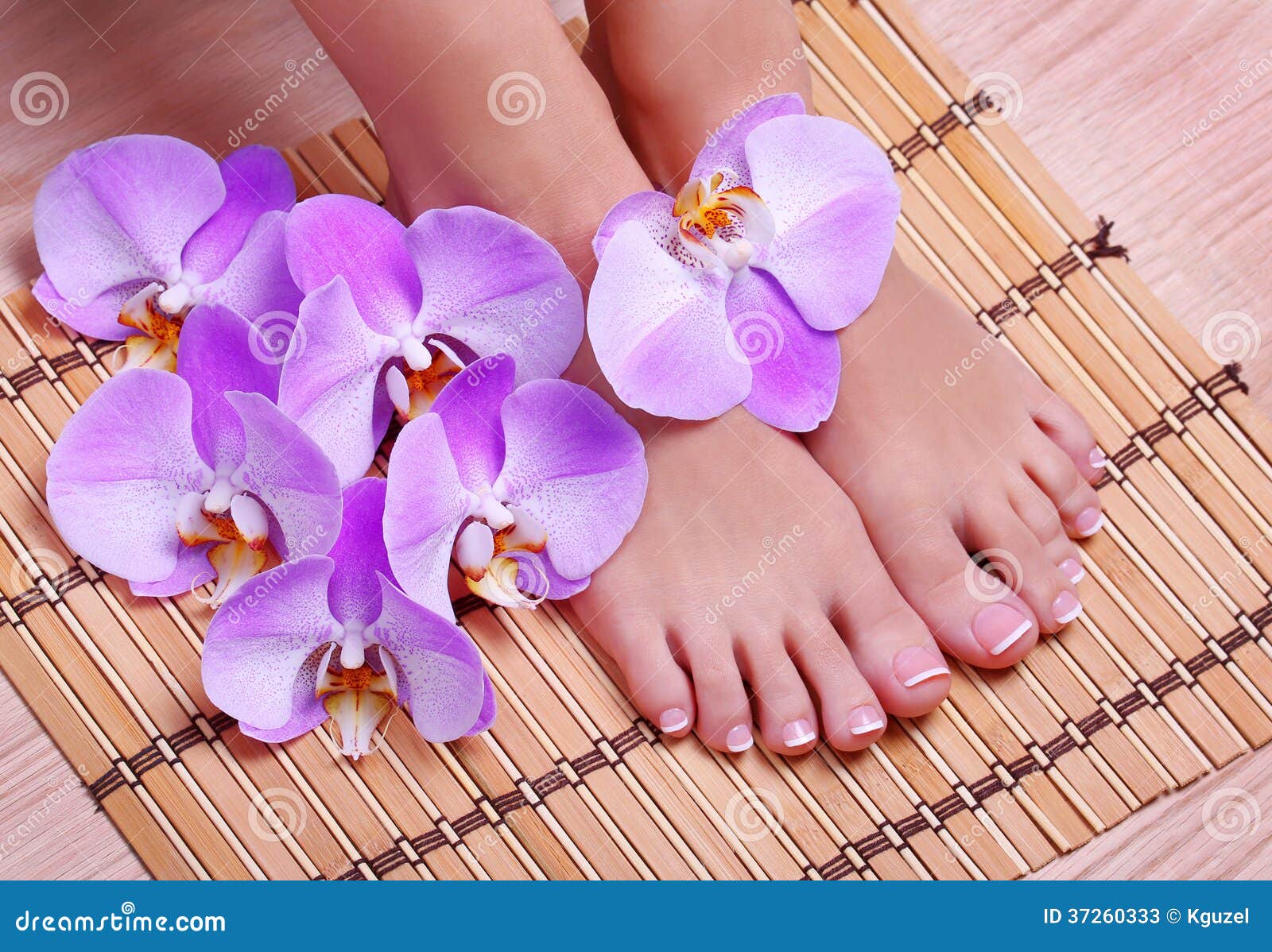 pedicure with pink orchid flowers on bamboo mat