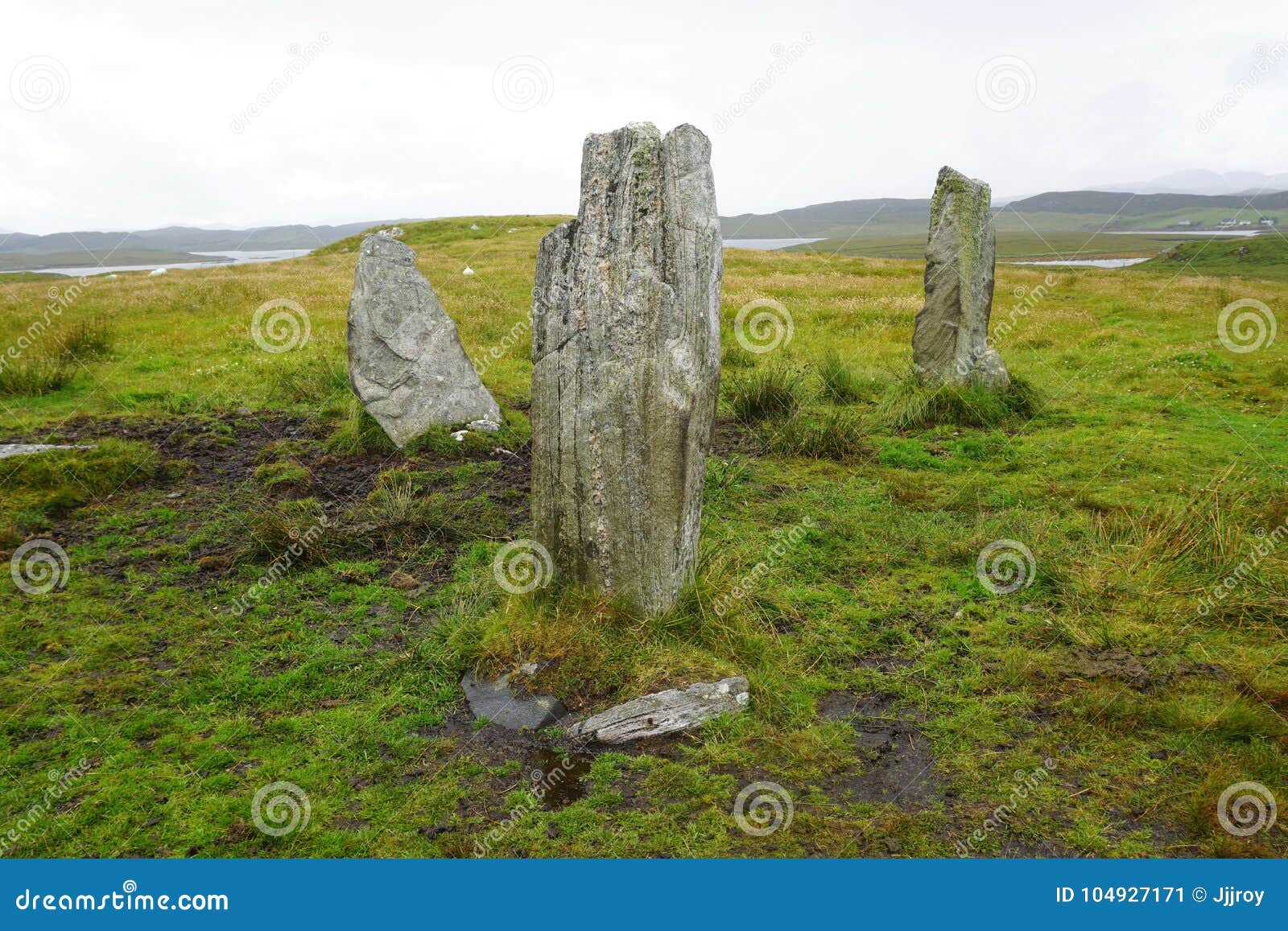 Pedras eretas em Lewis Island, Hebrides exterior. Um círculo áspero de pedras eretas Neolíticos antigas em Lewis Island no ` s Hebrides exterior de Escócia As pedras são ficadas situadas em um pasto aberto Ao contrário das pedras eretas famosas em Stonehenge, os visitantes podem andar até a estas pedras para um olhar mais atento