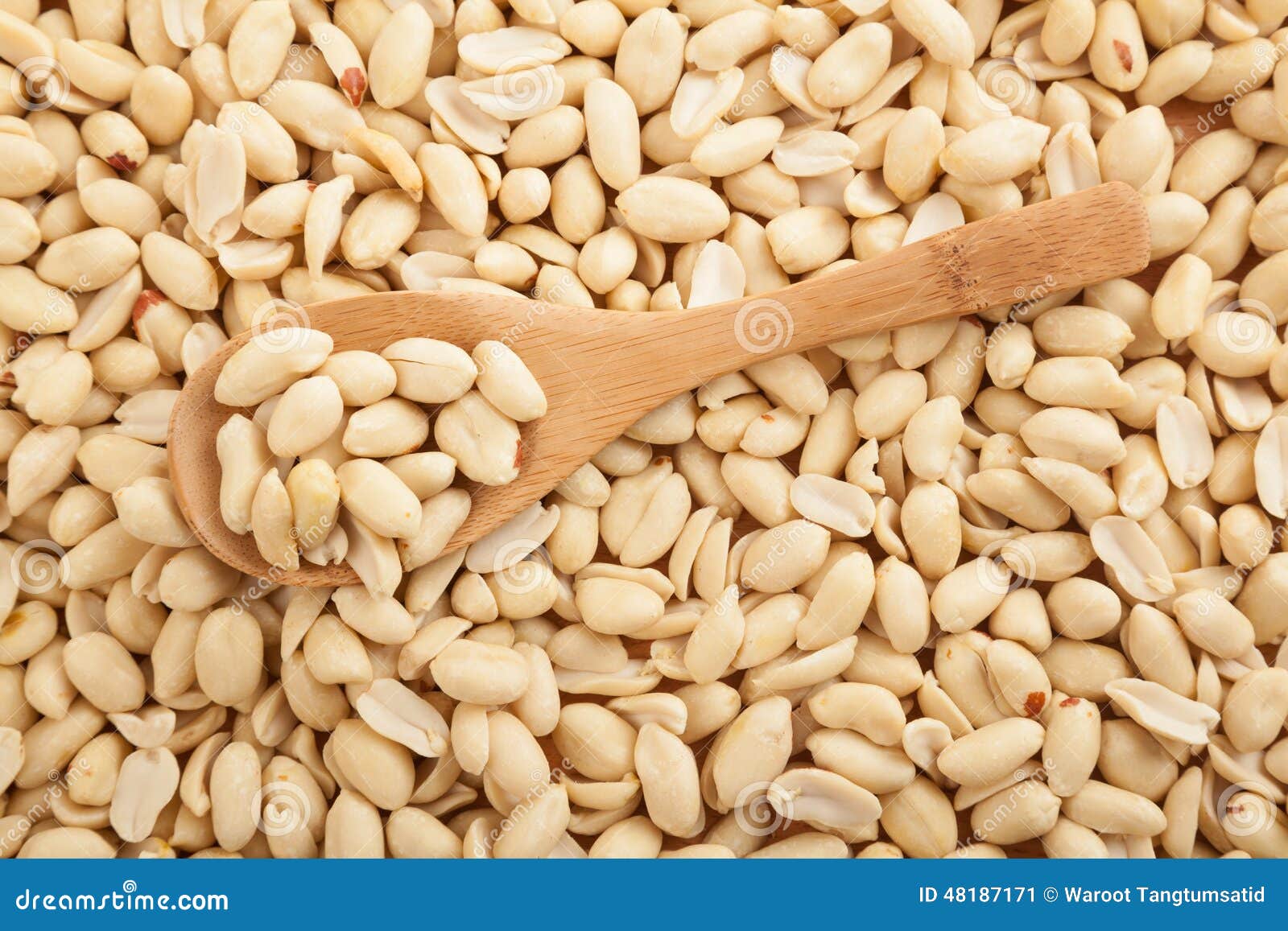 peeled peanuts with wooden spoon