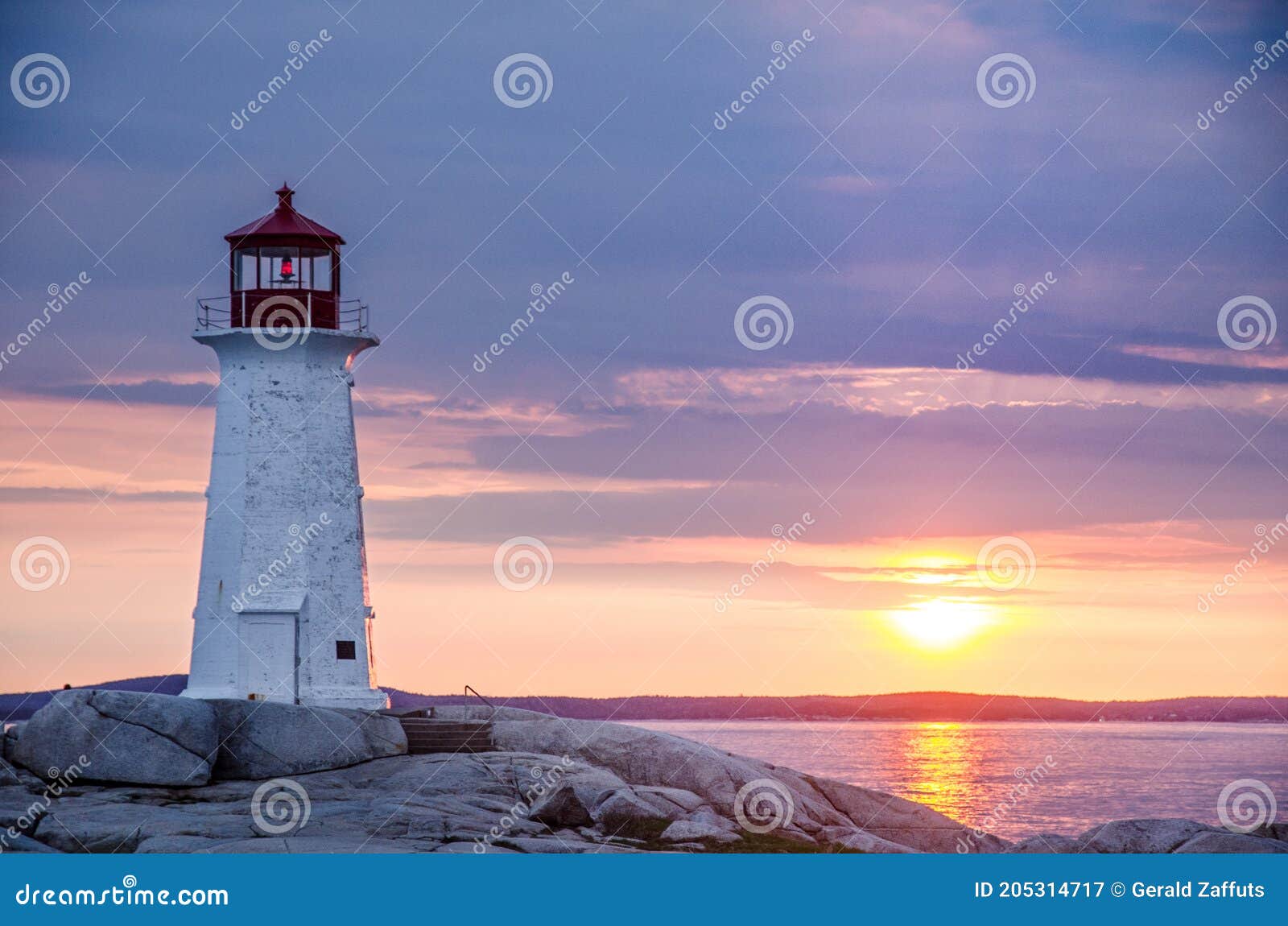 peggy`s cove lighthouse at sunset with storm clouds
