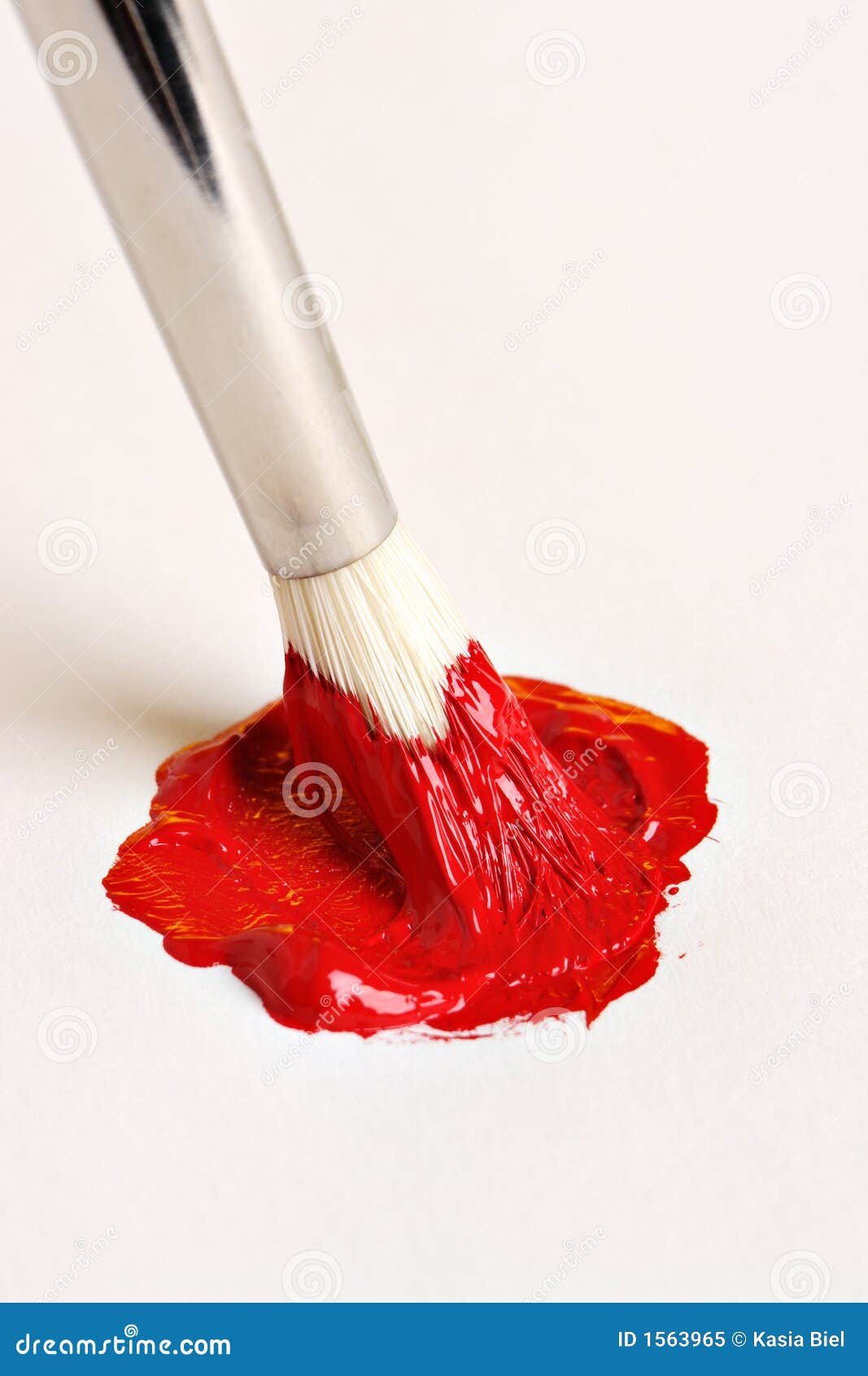 Balai mélangeant la peinture rouge sur la toile