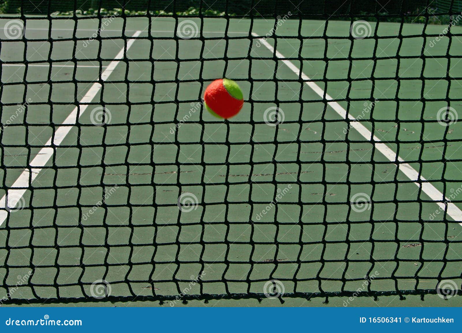 Pelota de tenis en la red. Bolas Amarillo-rojas en un campo de tenis verde