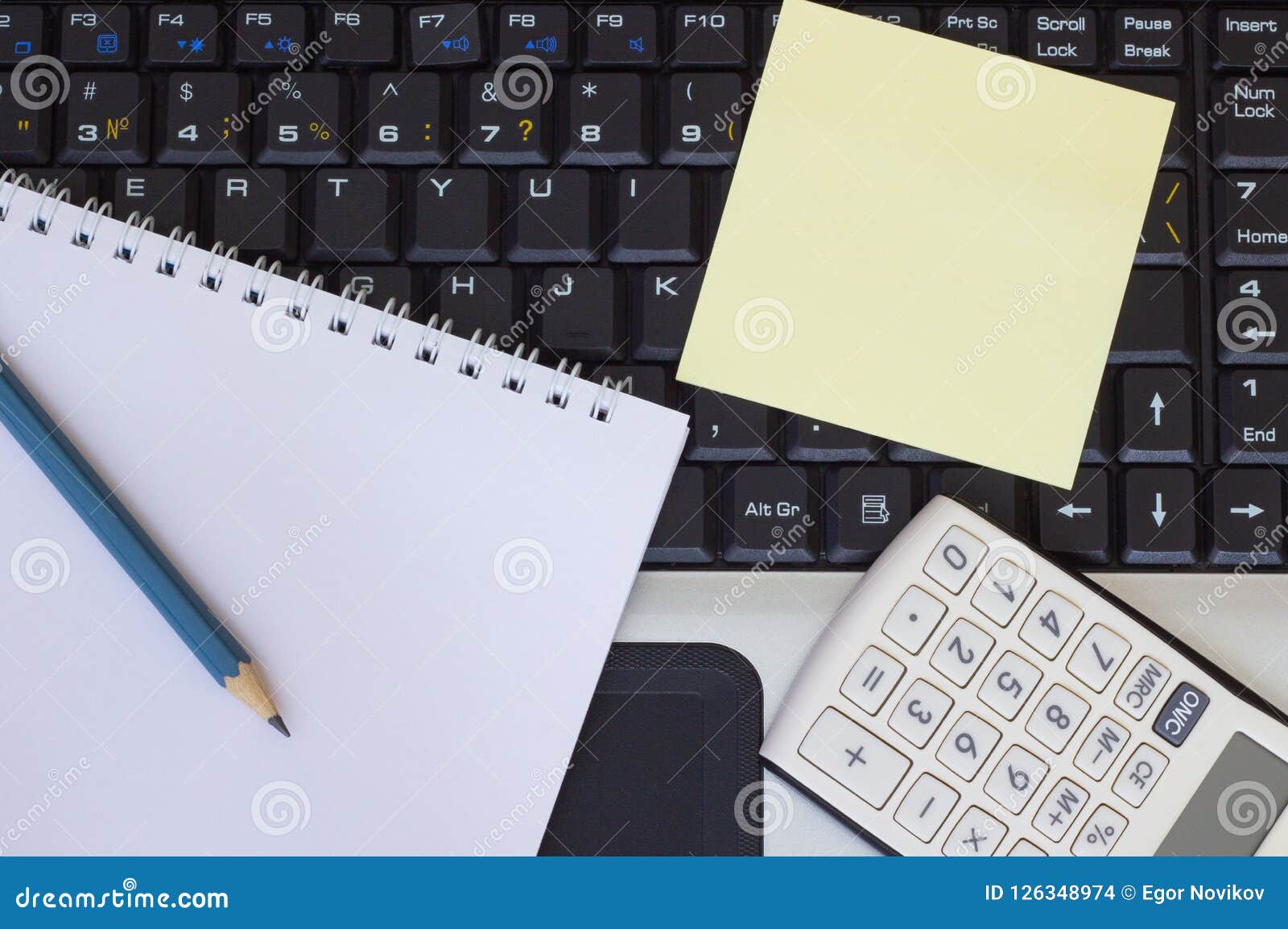 Pencil, Notebook and Calculator on Laptop Keyboard Stock Photo Image
