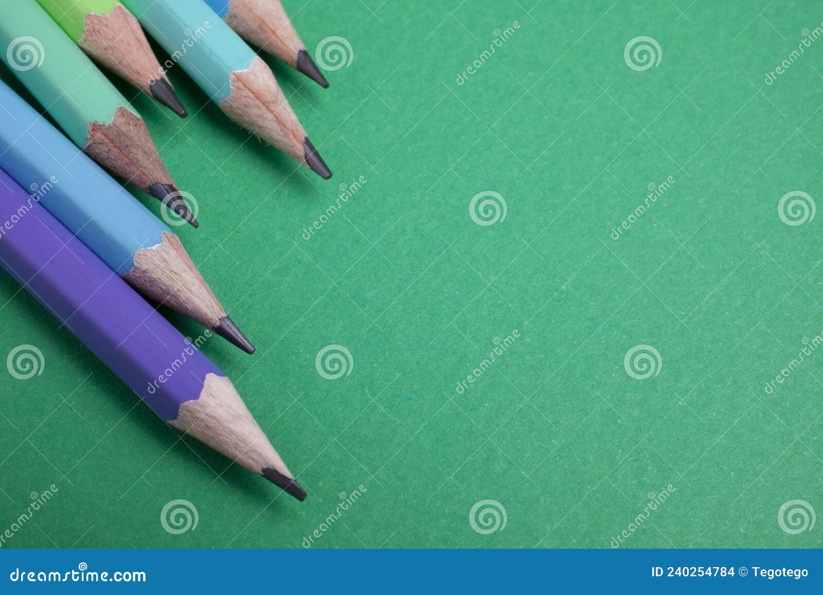 pencil placed on green paper background with copy space