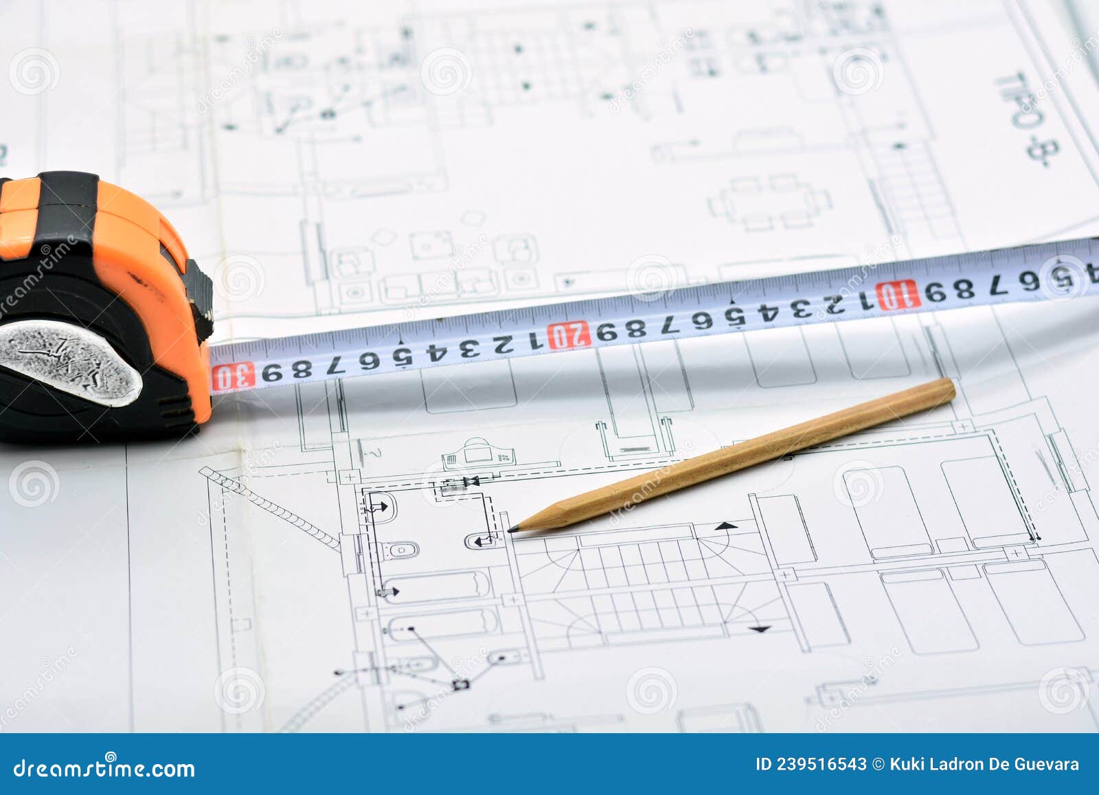 pencil, ruler and magnifying glass on top of a plan