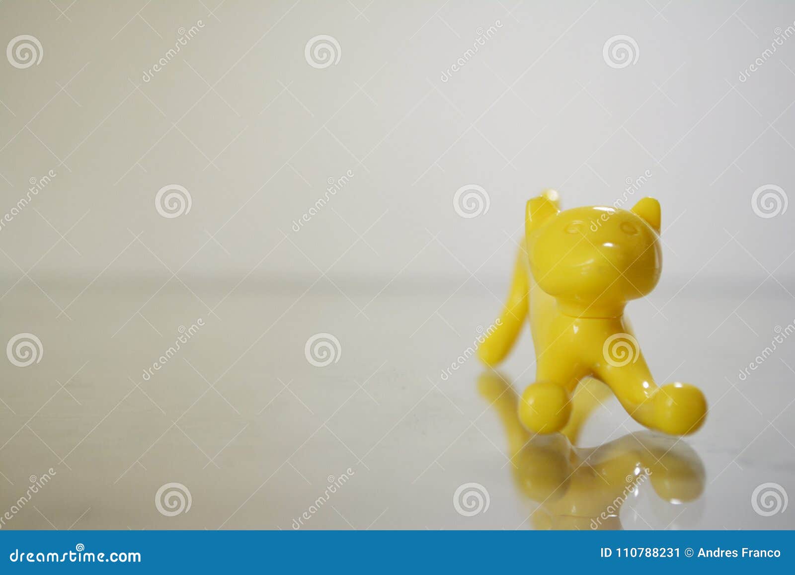 a pencil d yellow toy cat in a frontal angle, small, cute and curious