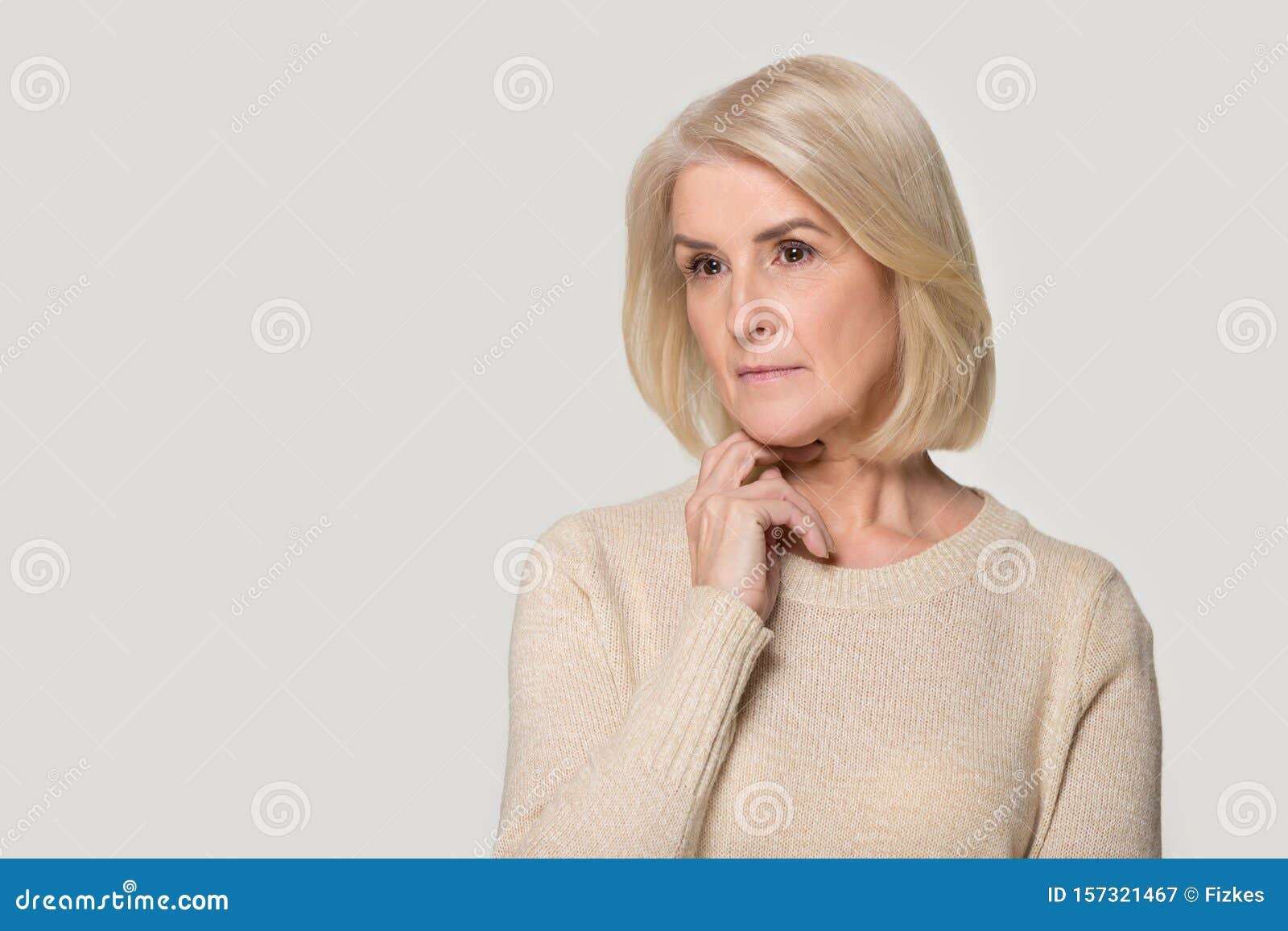 pensive senior woman  on grey background thinking