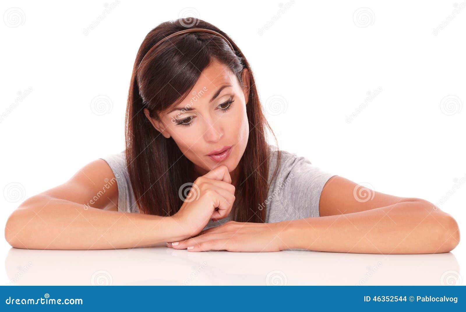 Portrait of pensive young woman wondering while looking down on isolated white background - copyspace