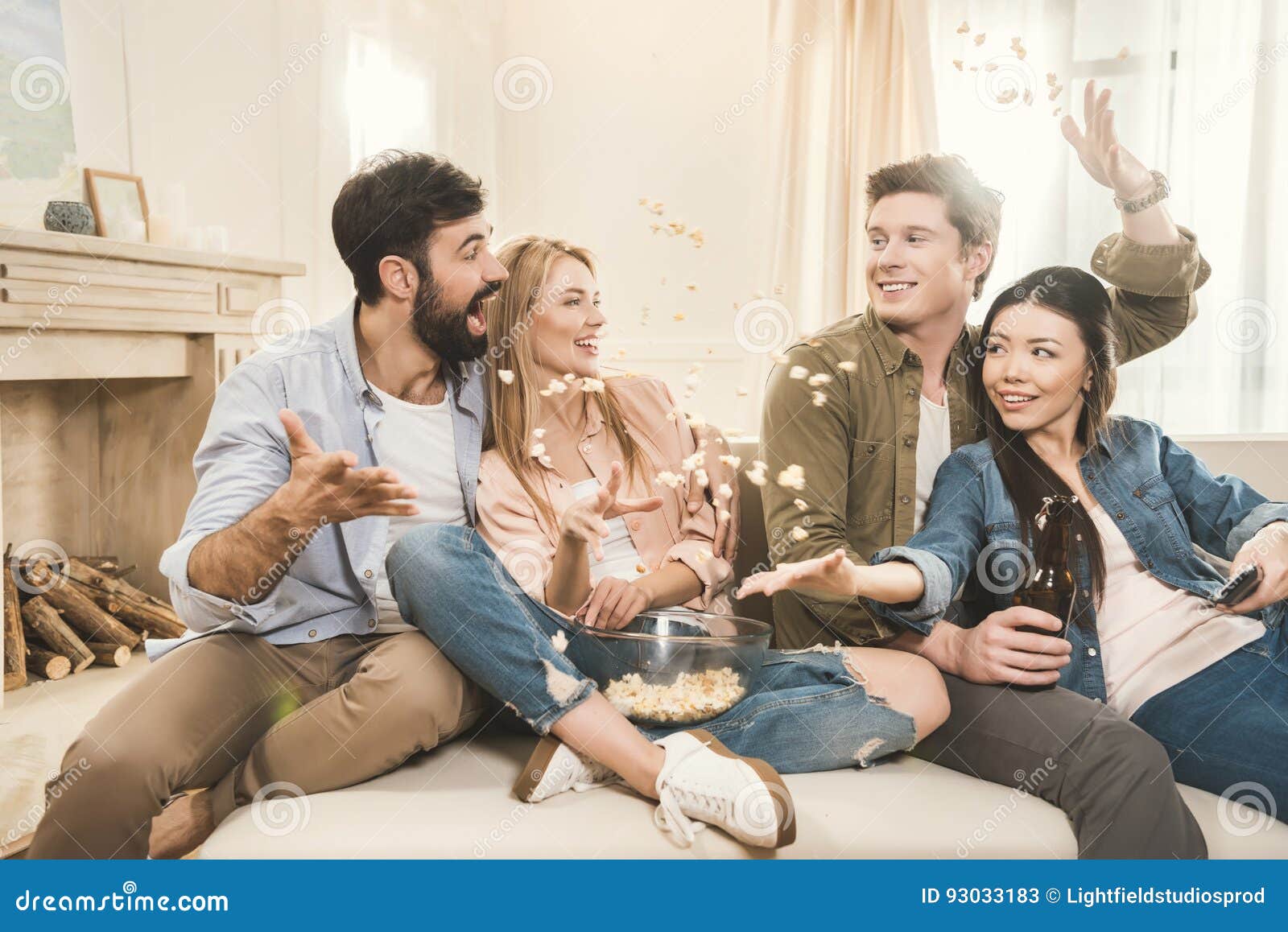 People on Couch Throwing Popcorn Upside Stock Image Image of male