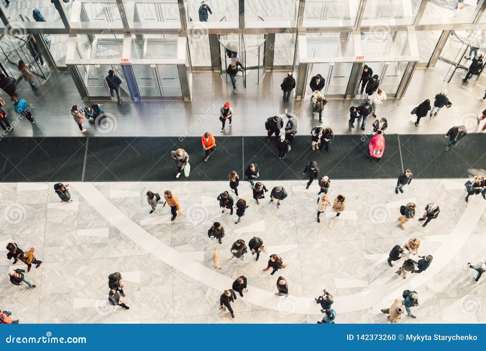 people crowd walking in the business centre and shopping mall entrance. view from the top.