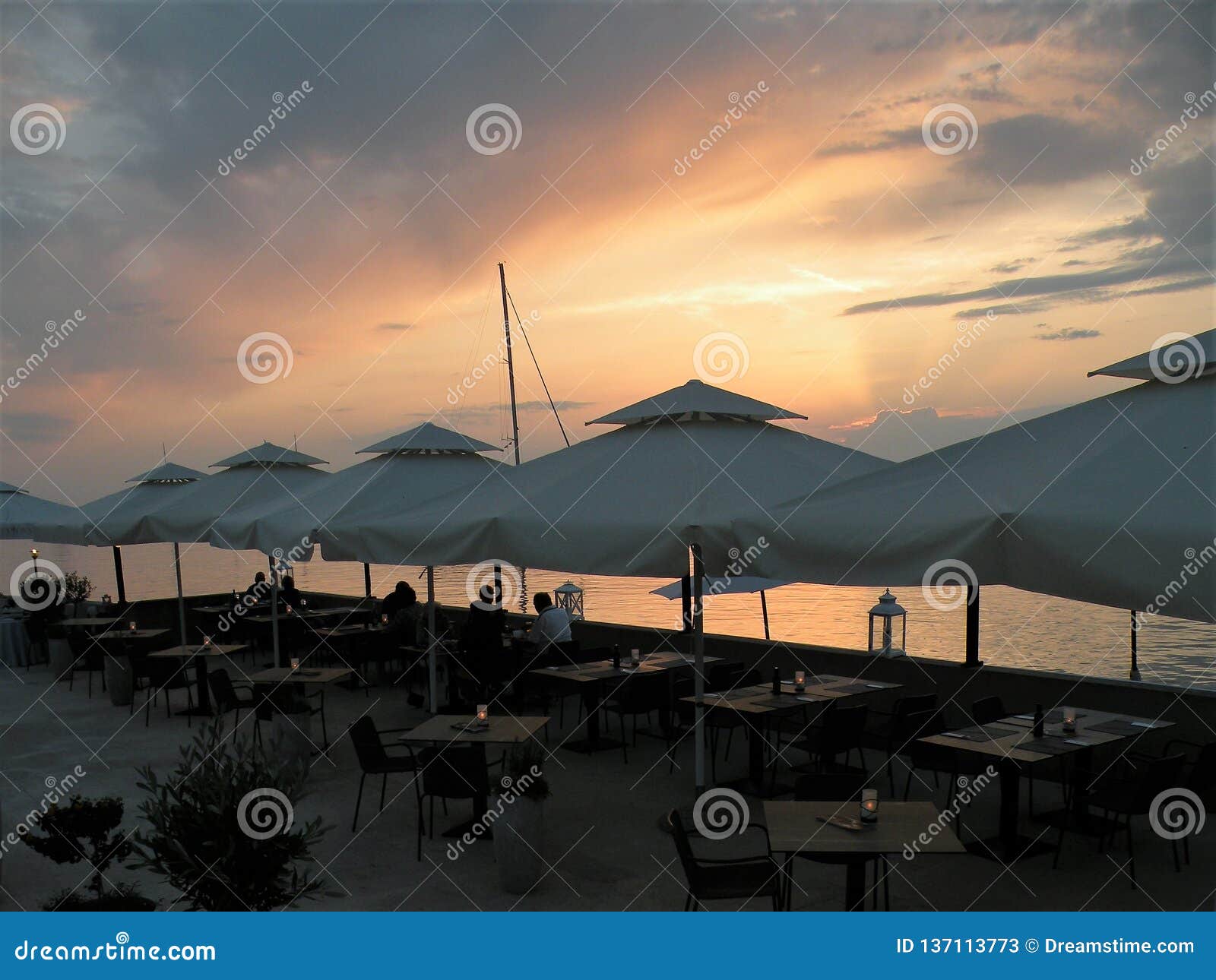 People at Dinner, Tables Under White Umbrellas.Restaurant by the Sea ...