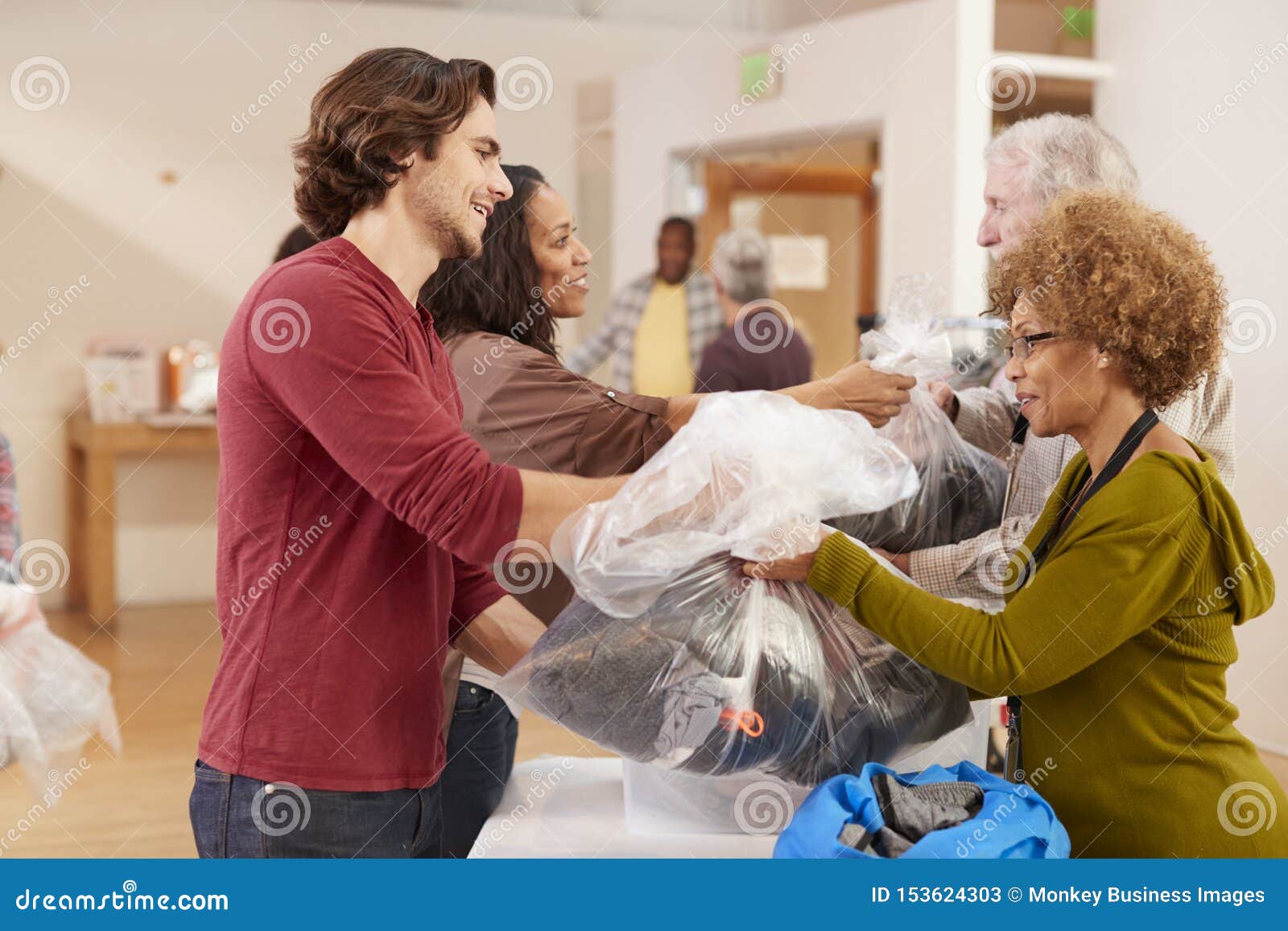 people donating clothing to charity collection in community center