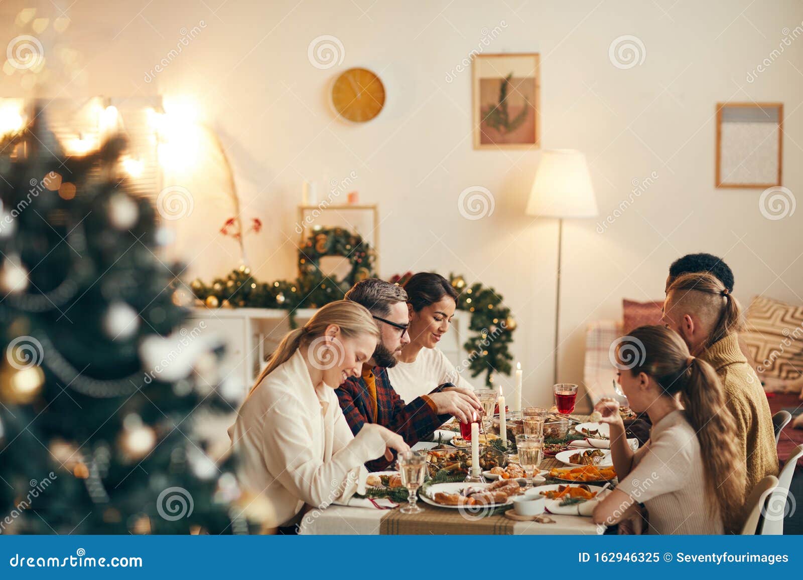 People Enjoying Christmas Dinner in Elegant Interior Stock Image