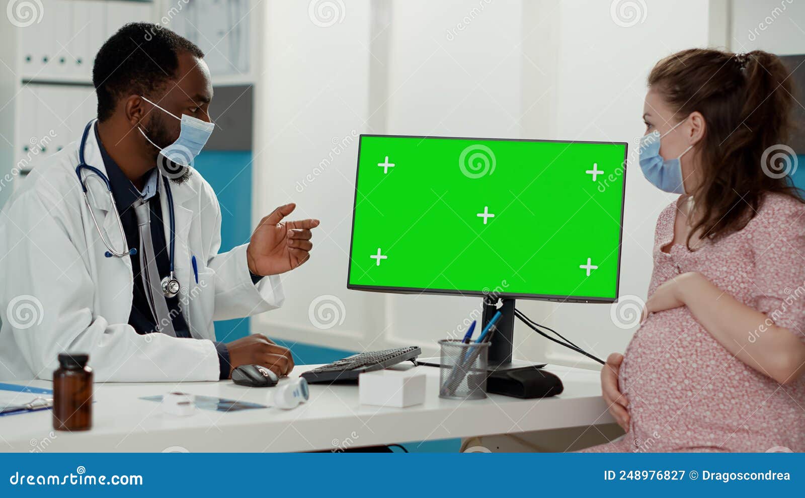 People with Face Mask Using Computer with Greenscreen Stock Image