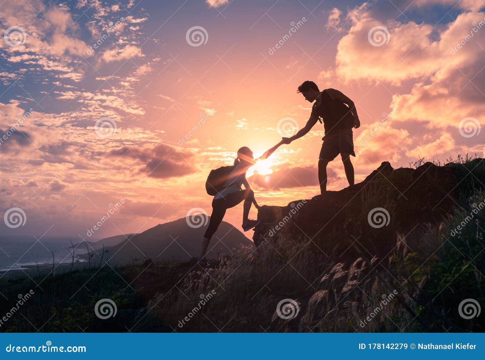 people helping each other hike up a mountain at sunrise. giving a helping hand.