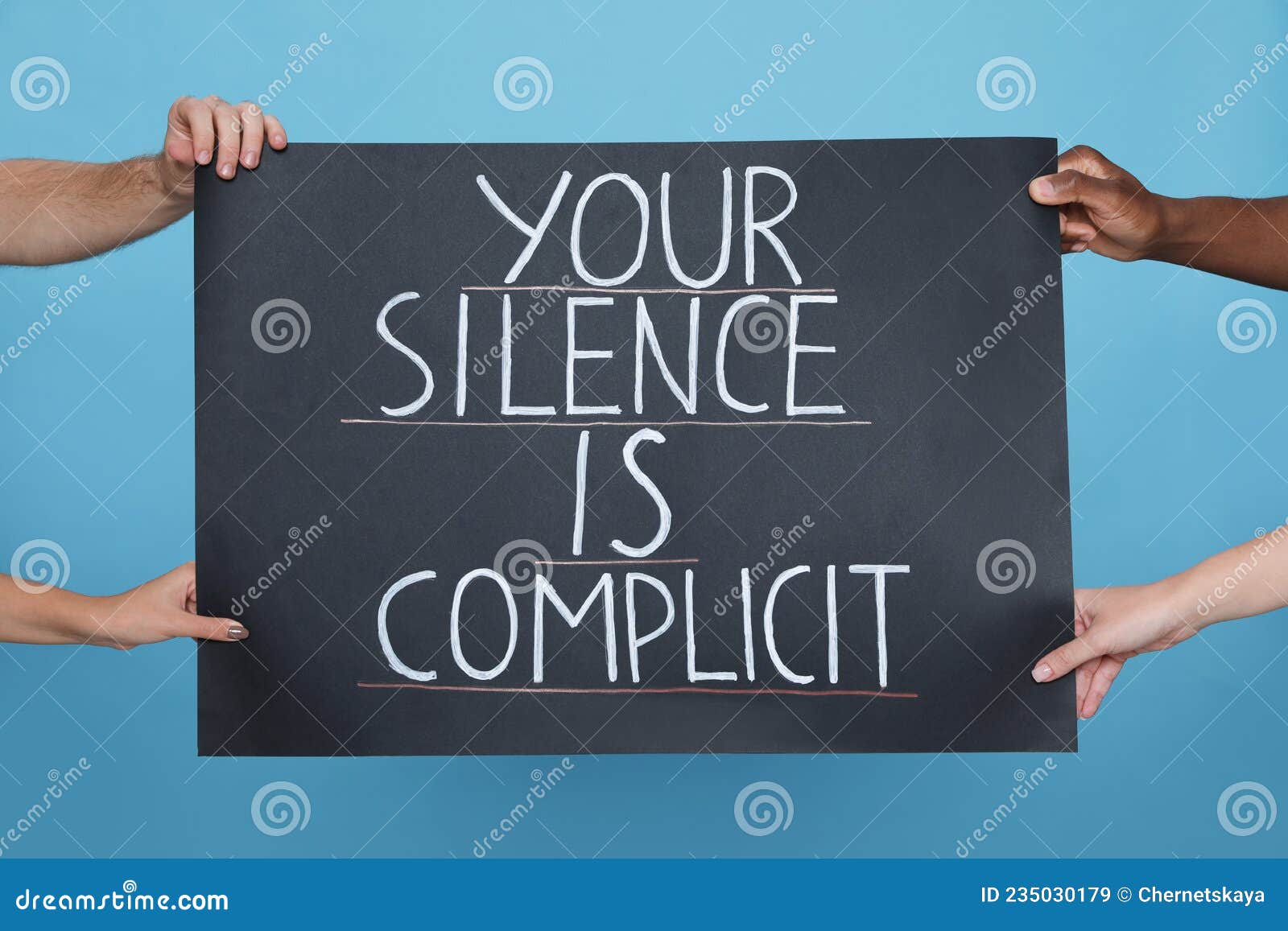 people holding sign with phrase your silence is complicit on light blue background, closeup. racism concept