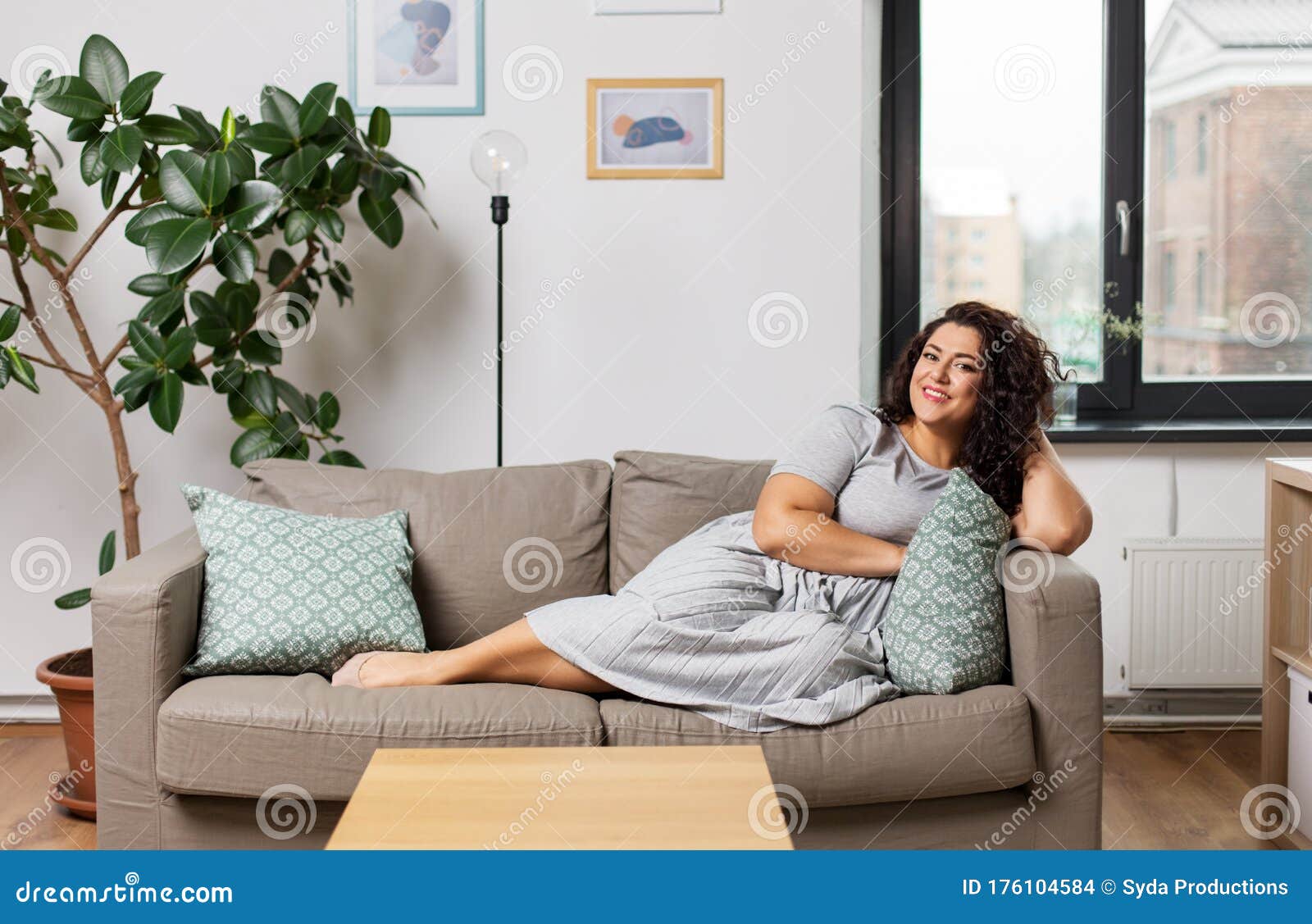 Happy Young Woman Lying on Sofa at Home Stock Photo - Image of ...