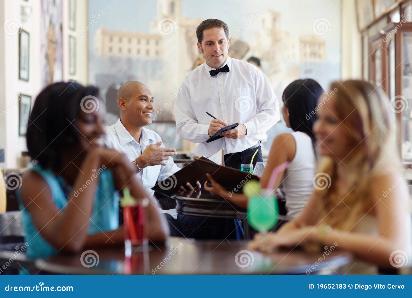 people ordering meal to waiter in restaurant