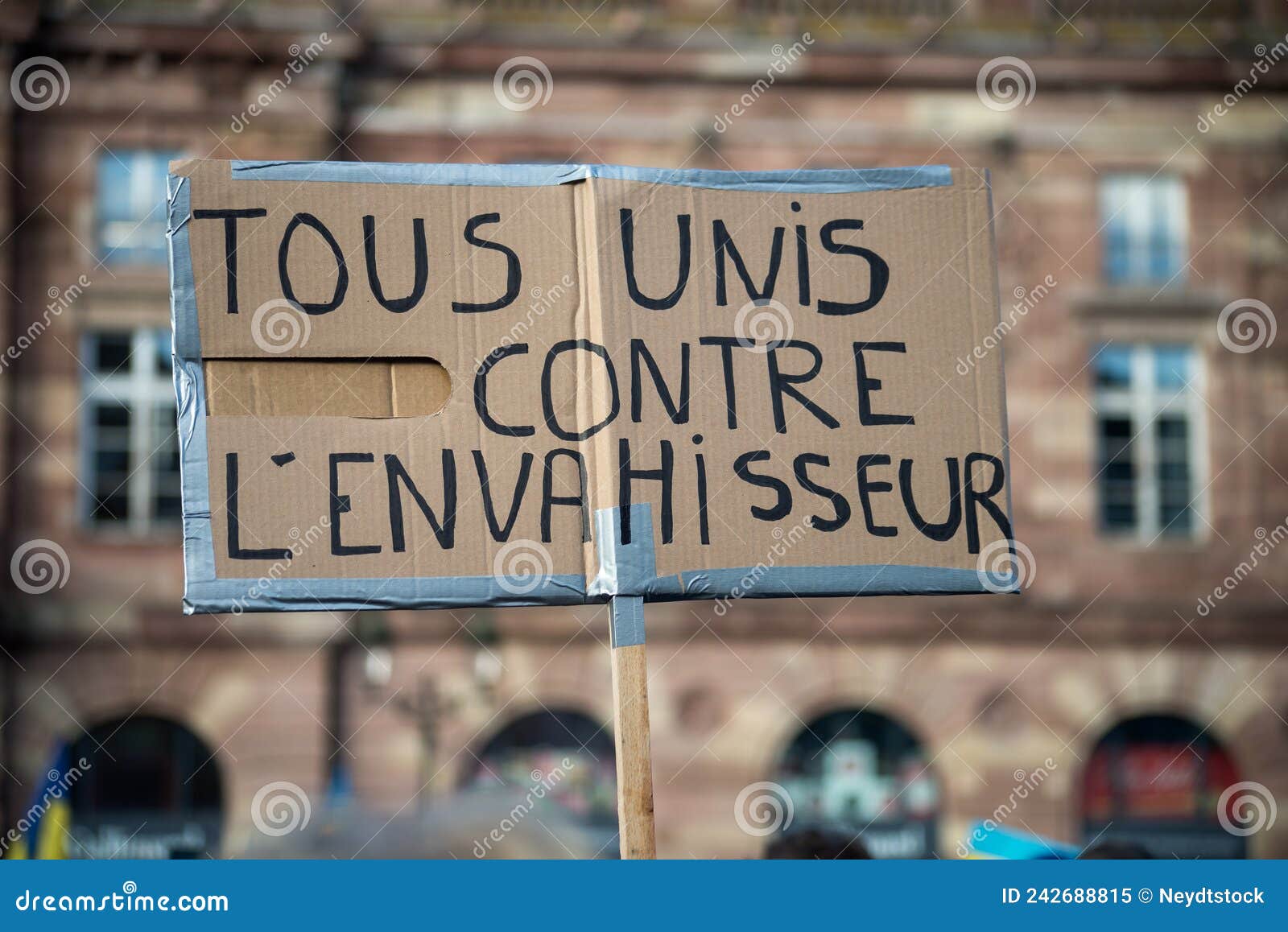 people protesting against the war with text in french : tous unis contre l`envahisseur, in english : all united against the