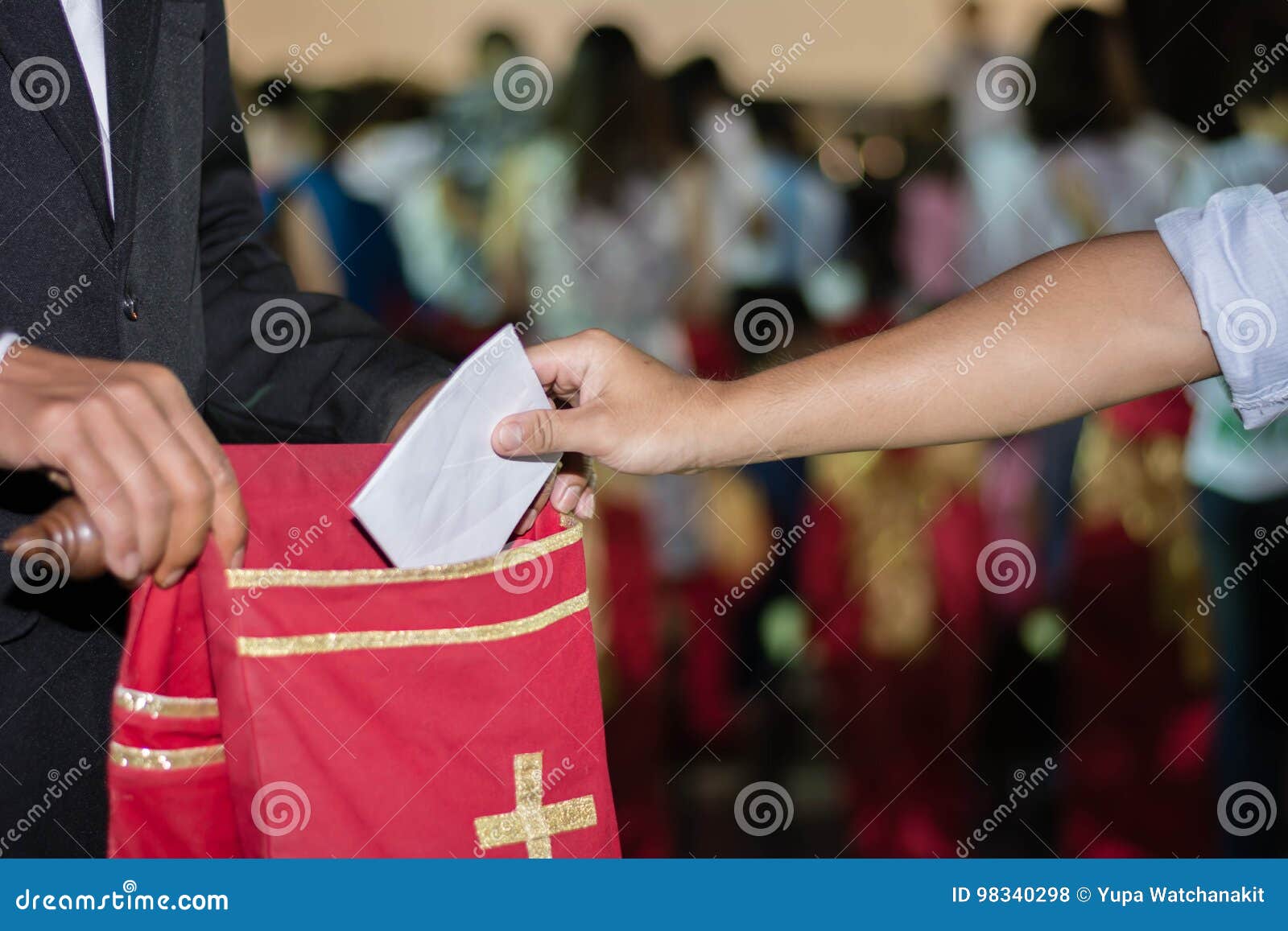 people putting tithing into velvet offering bag in church