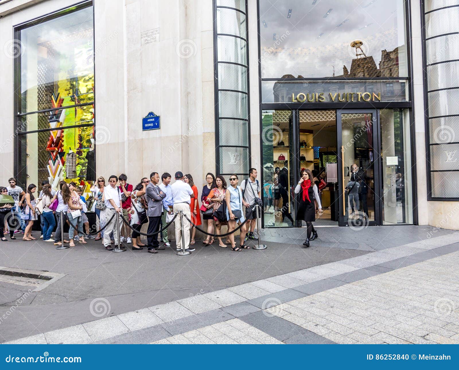 Queue of shoppers outside Louis Vuitton store on Champs Elysees in