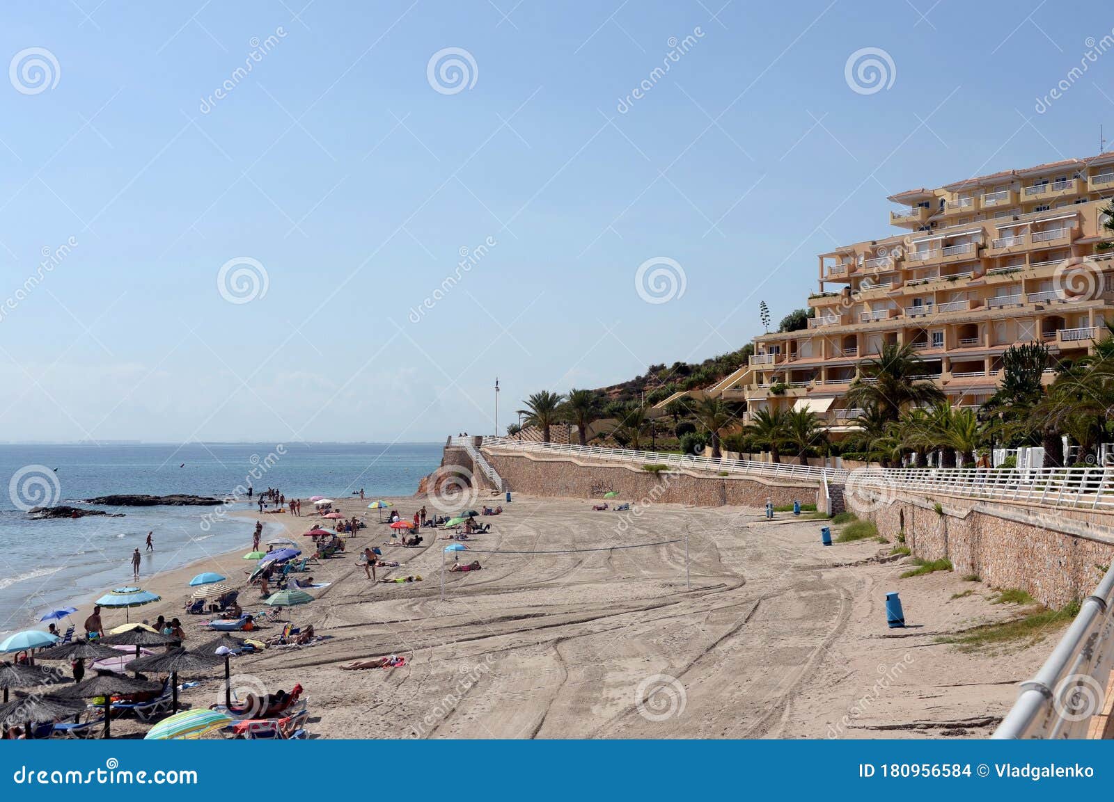 people relax on the sandy beach of playa de aguamarina, province of alicante, spain