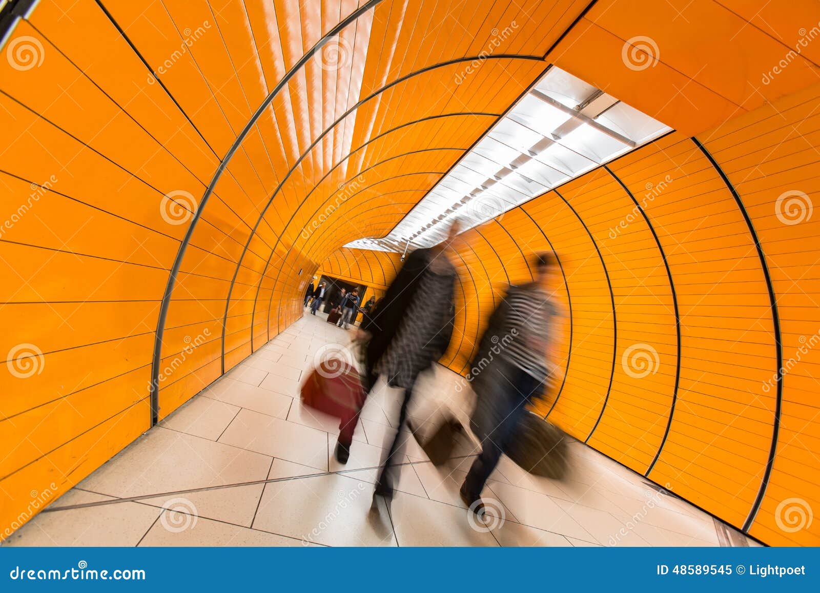 people rushing through a subway corridor