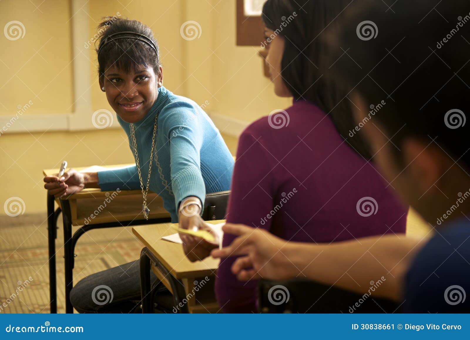 people at school, group of students passing note during lesson