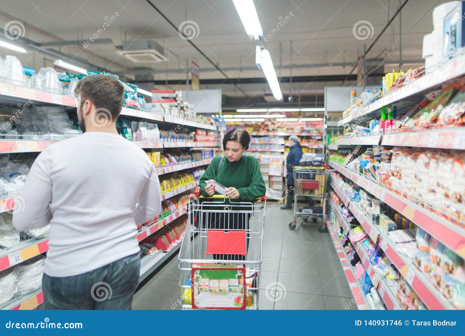 People Shop at a Supermarket. a Girl Walks through a Supermarket, a Man ...